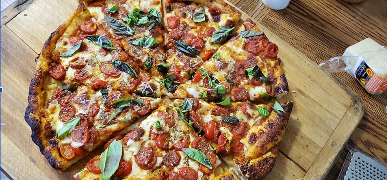 A homemade pizza on a wooden serving board. (Photo from Wikimedia Commons)