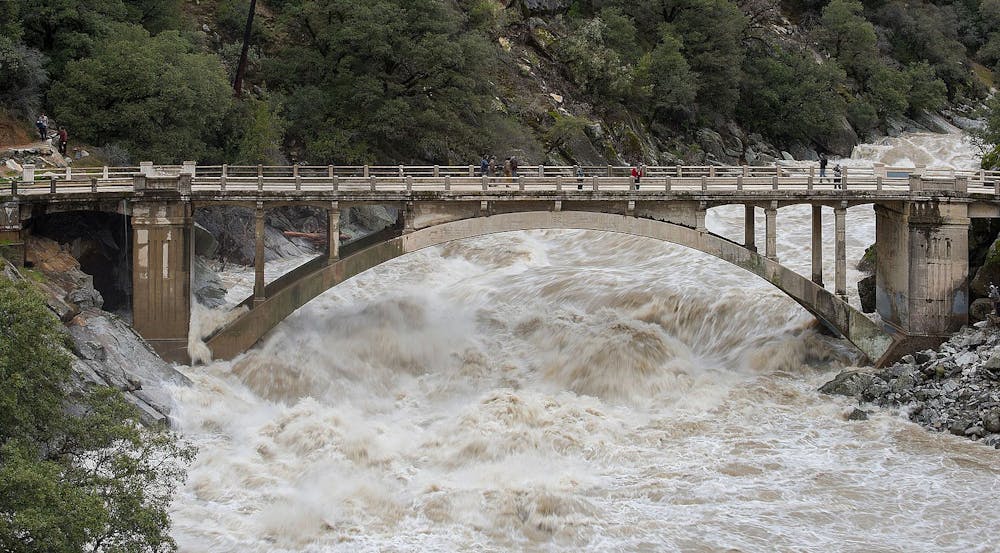 <p><em>Just one month into the new year, people are already experiencing intense flooding and destruction across California as homes and schools are left as debris (Photo courtesy of </em><a href="https://commons.wikimedia.org/wiki/File:Flood_under_the_Old_Route_49_bridge_crossing_over_the_South_Yuba_River_in_Nevada_City,_California.jpg" target=""><em>Wikimedia Commons</em></a><em> / “Flood under the Old Route 49 bridge crossing over the South Yuba River in Nevada City, California” by Kelly M. Grow/ California Department of Water Resources. PD California. January 9, 2017). </em></p>