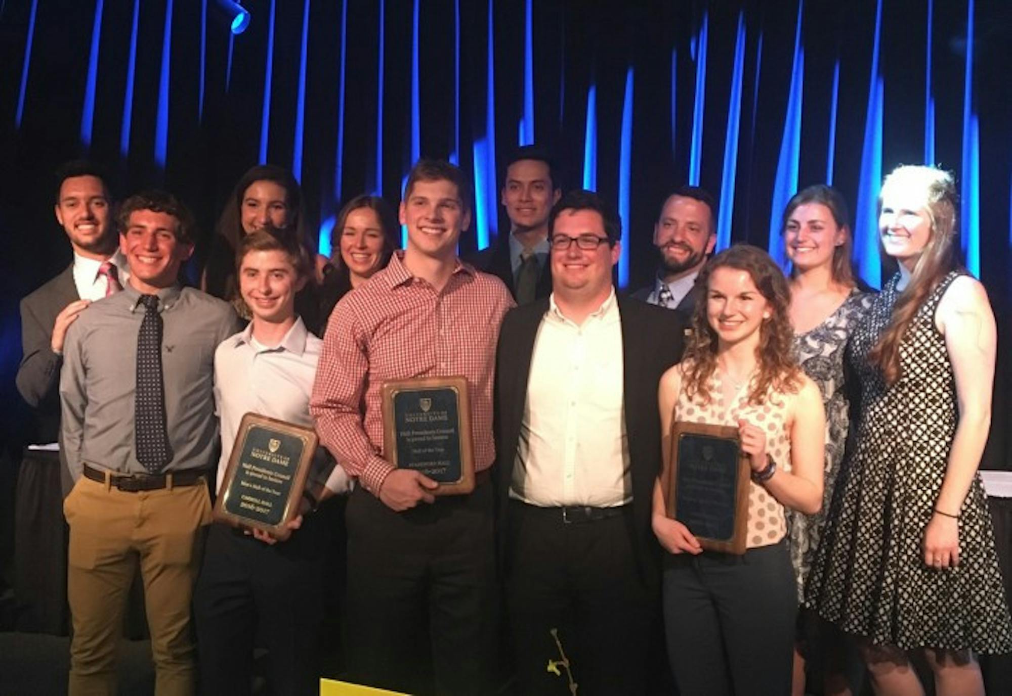 Members of the three winning halls, Stanford, Farley and Carroll, pose with plaques honoring their dorms’ achievements. The Hall of the Year winners were announced in an event held at Legends.
