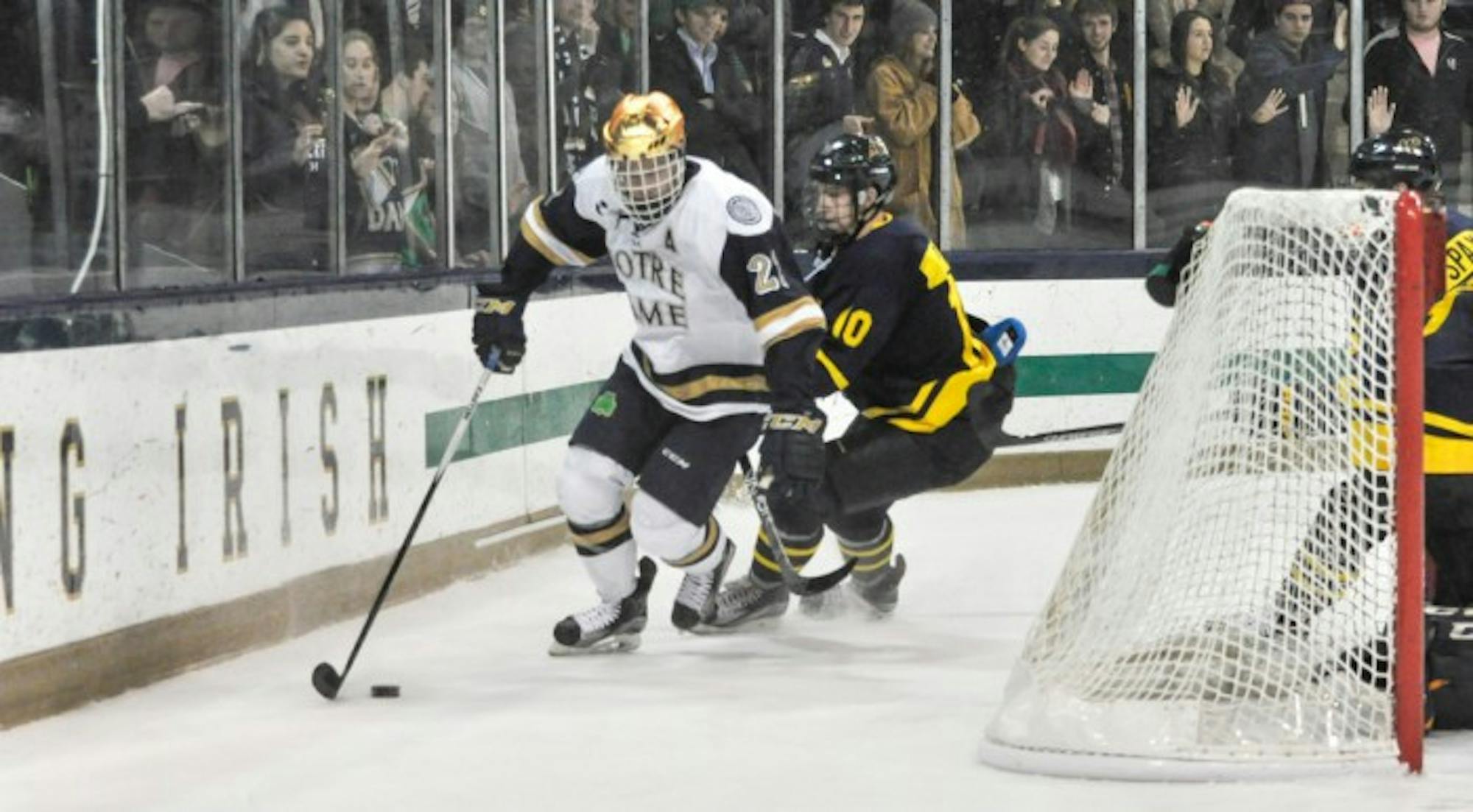 Irish senior left wing Mario Lucia fends off a Merrimack player during Notre Dame’s 7-2 win Friday at Compton Family Ice Arena.