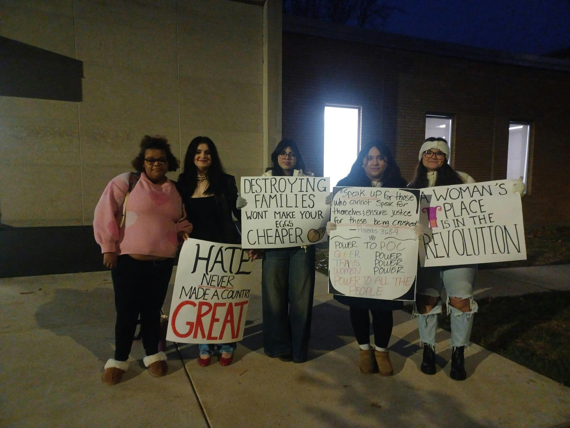 Student protesters hold signs calling out TPUSA event