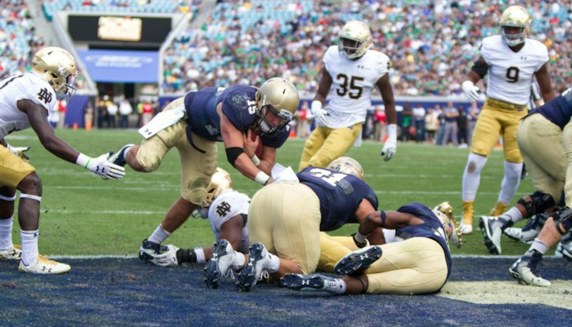 Navy senior quarterback Will Worth dives into the end zone during Notre Dame's 28-27 loss to the Midshipmen on Saturday in Jacksonville. Worth ran for 175 yards and two touchdowns in the Navy win.