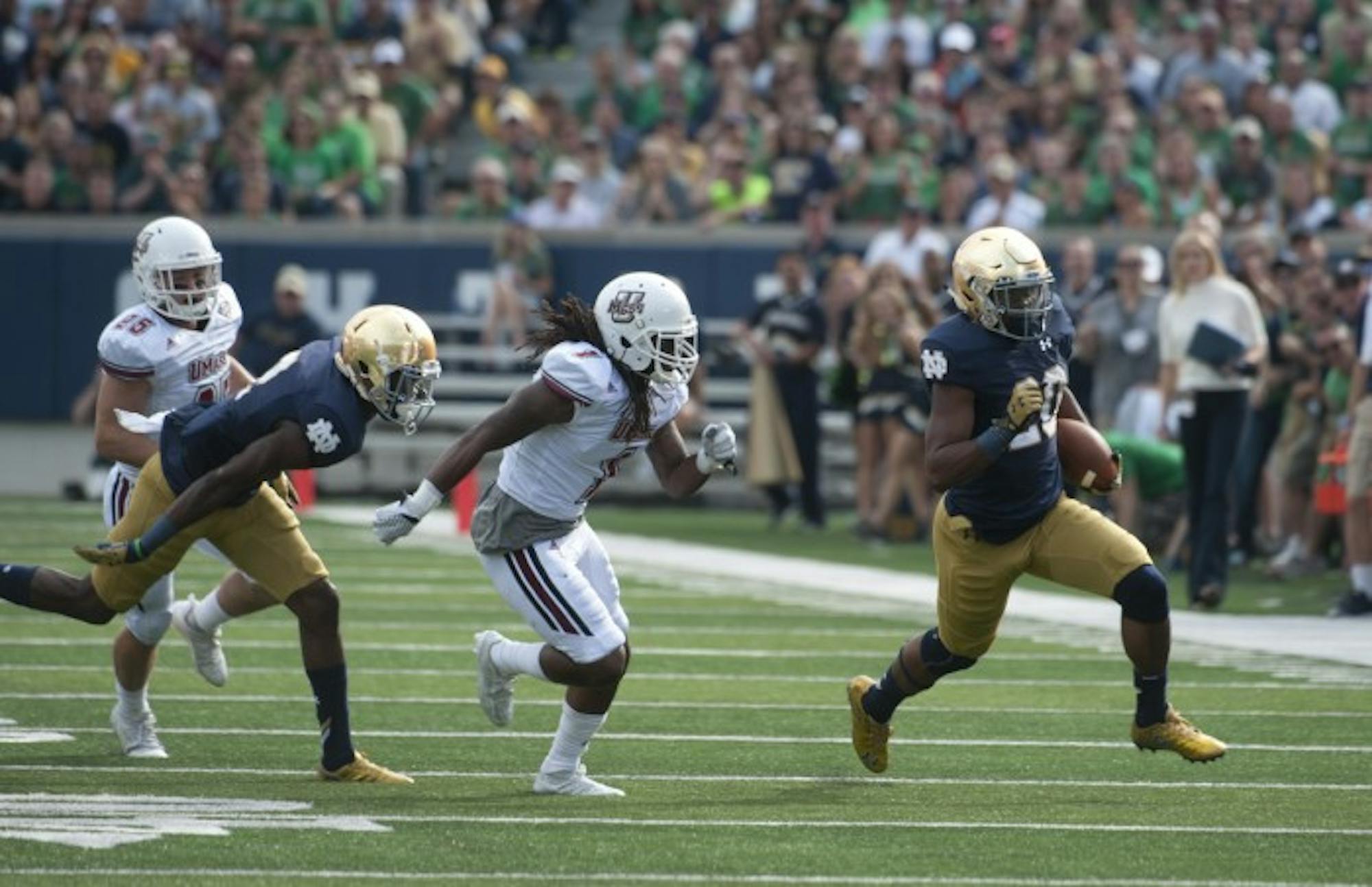 Irish senior running back C.J. Prosise turns the corner during his first-quarter, 57-yard touchdown run that opened the scoring in Notre Dame’s 62-27 win over Massachusetts on Saturday at Notre Dame Stadium. It was the first of two scores on the day for Prosise, who topped 100 rushing yards for the third consecutive game.