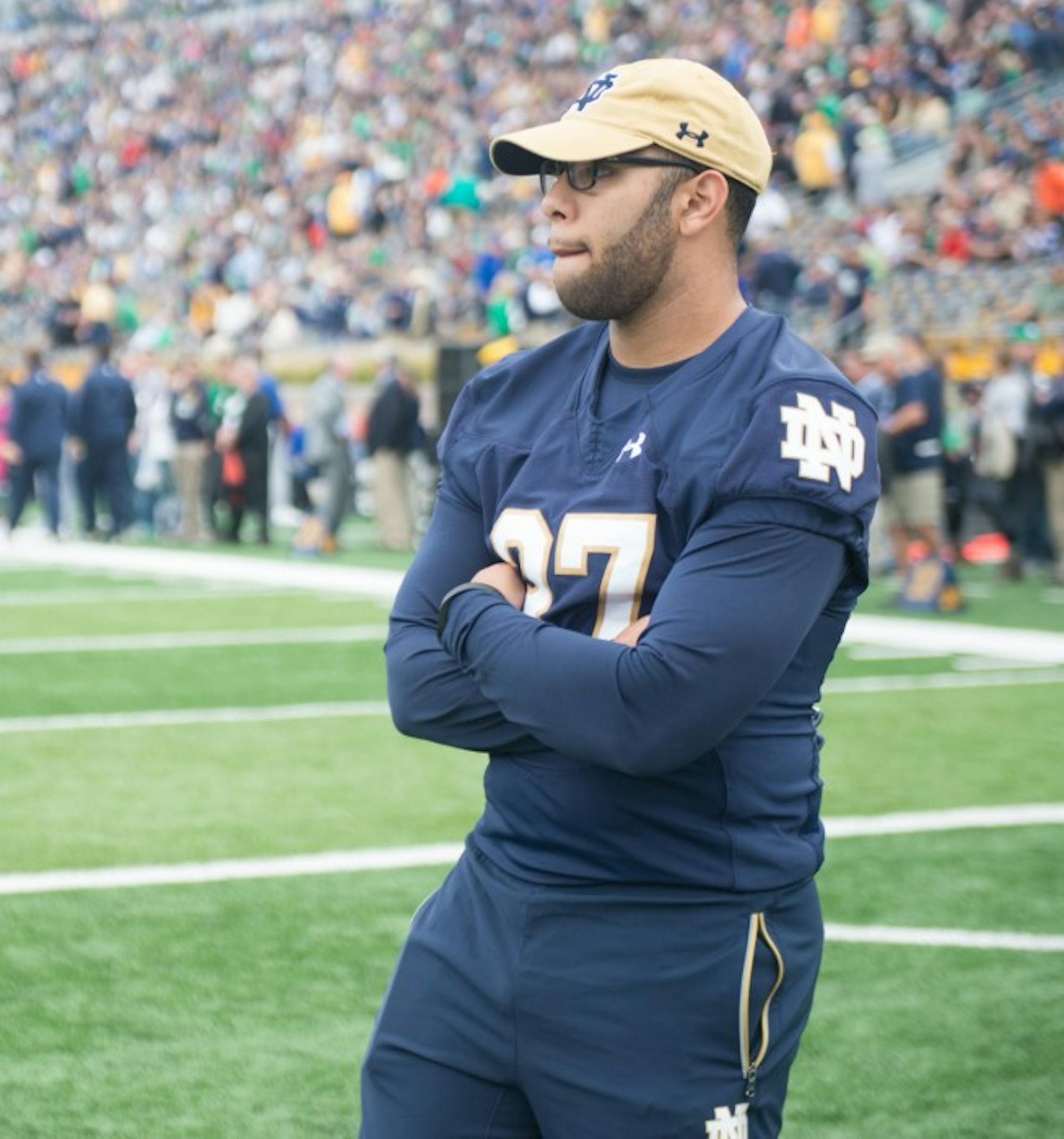 Irish senior receiver Omar Hunter, still recovering from a torn ACL, takes in warm ups in street clothes before the Irish took on Miami.