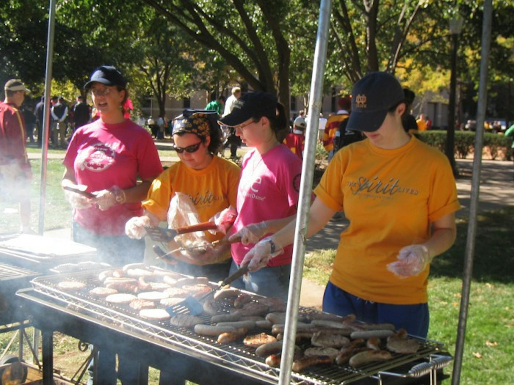Members of the Society of Women Engineers grill hot dogs and hamburgers before a Notre Dame football game as part of its fundraising efforts.