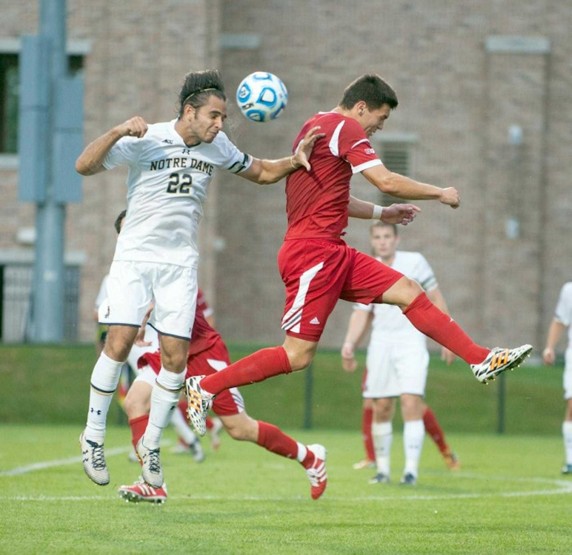 Irish senior defender Luke Mishu elevates over a Badger forward to head the ball in No. 1 Notre Dame’s 5-1 win against No. 21 Wisconsin on Monday at Alumni Stadium. Mishu played 59 minutes in the team’s final exhibition match of the season.