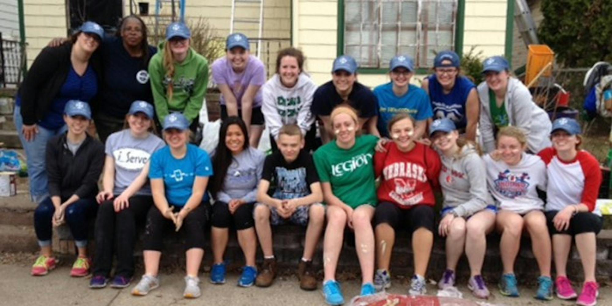 A group of Saint Mary’s Rebuilding Together volunteers poses in front of a local home they helped repair Saturday.