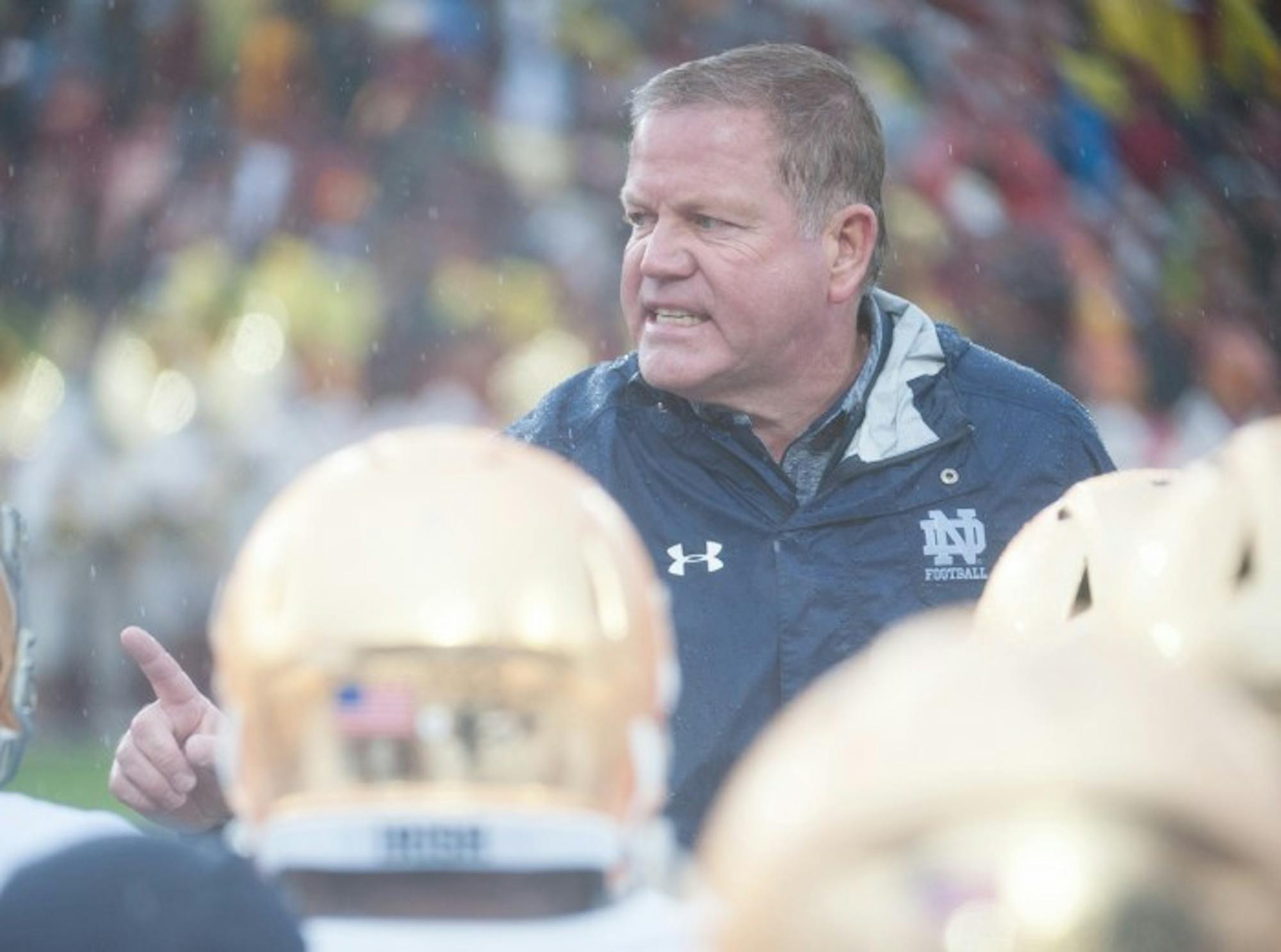 Irish head coach Brian Kelly addresses his team on the field during halftime of Notre Dame’s 45-27 loss against USC in Los Angeles on Nov. 26 at the Los Angeles Memorial Coliseum.