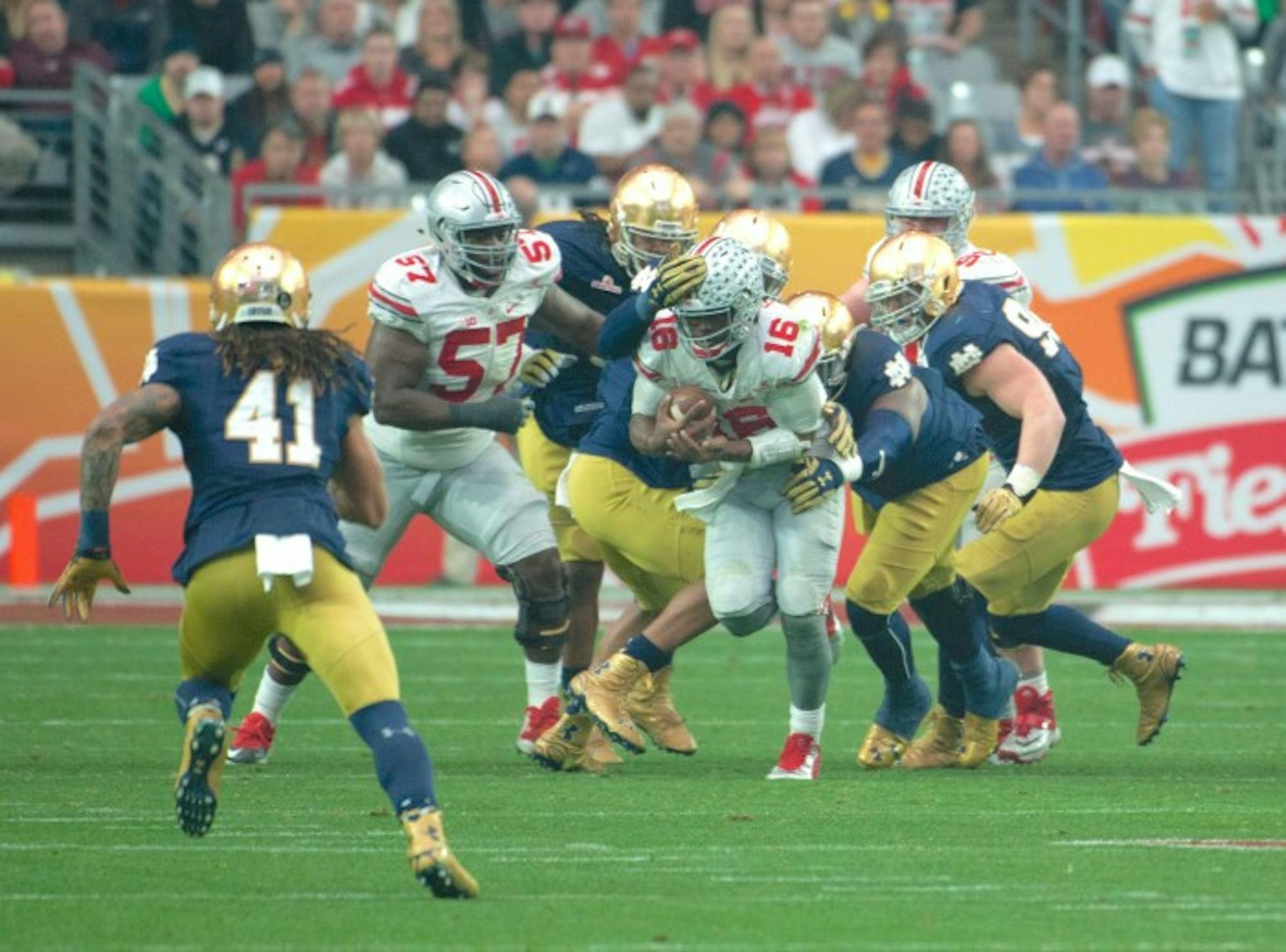 Notre Dame defenders swarm Ohio State sophomore quarterback J.T. Barrett as he scrambles for a gain during the Buckeyes' 44-28 victory over the Irish on Friday.