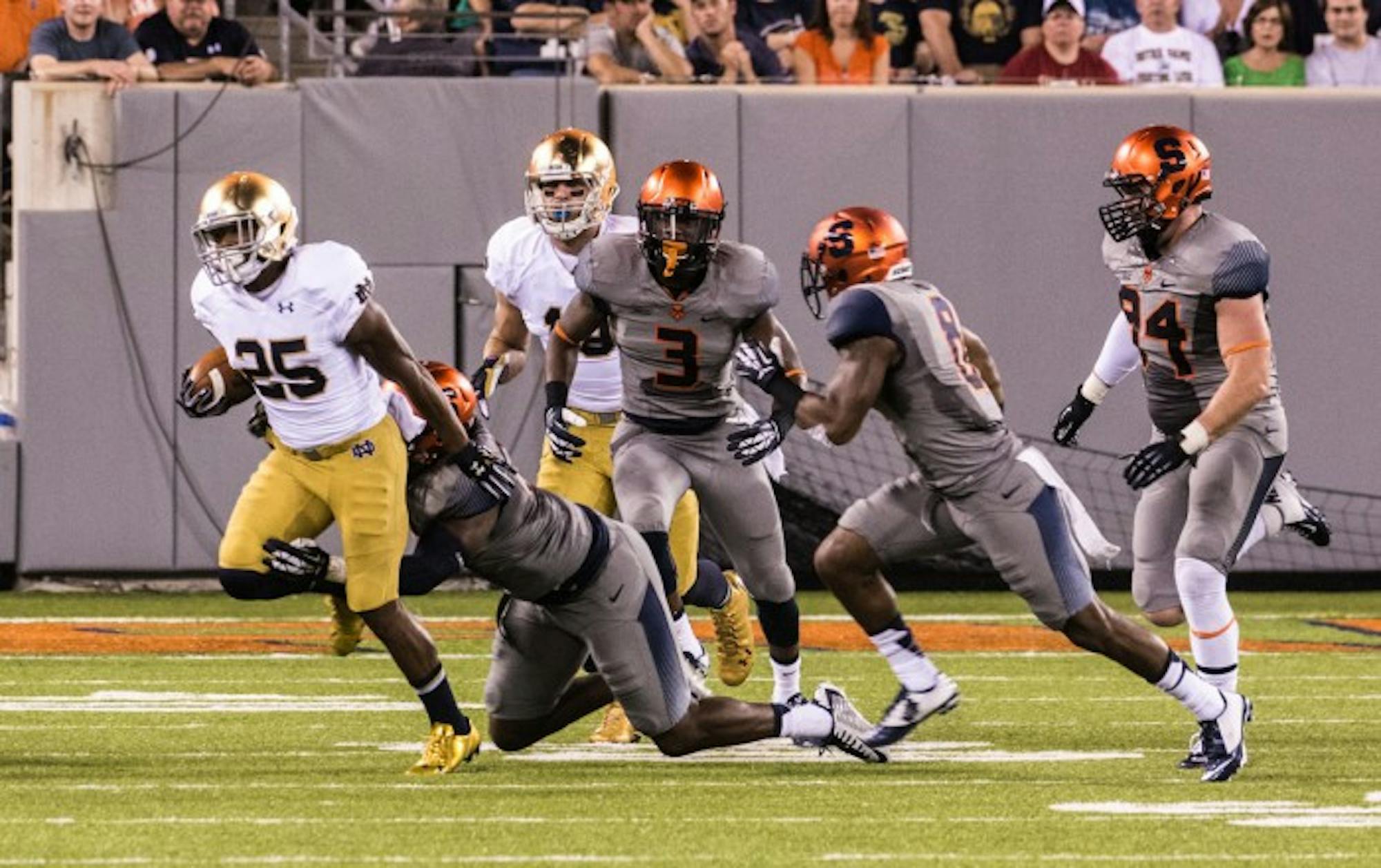 Senior running back Tarean Folston, then a sophomore, attempts to evade a tackler during Notre Dame’s 31-15 victory over Syracuse at the Carrier Dome on Sept. 27, 2014.