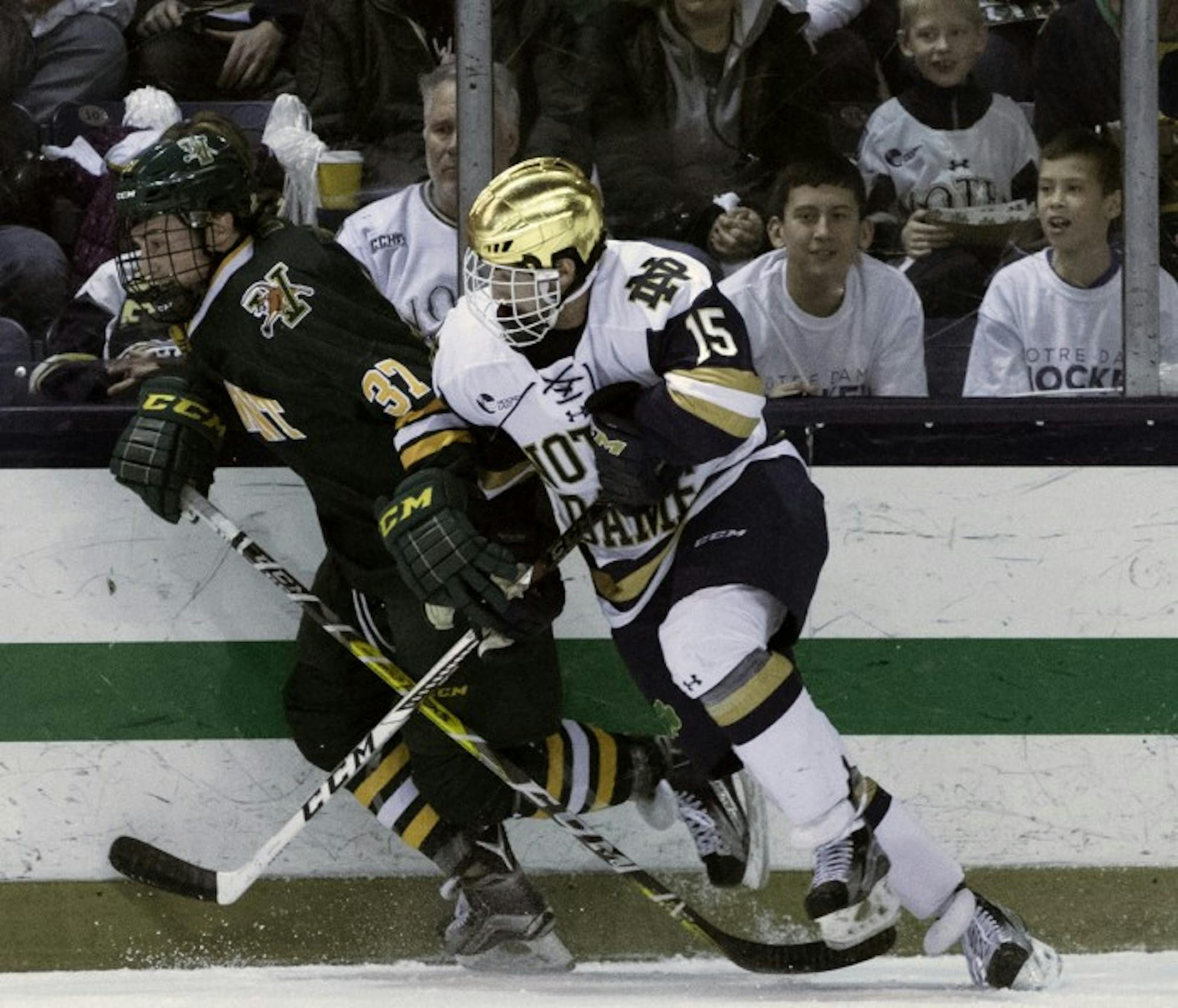 Irish sophomore forward Andrew Oglevie battles with a Vermont player along the boards during Notre Dame’s 4-4 draw with the Catamounts on Friday at Compton Family Ice Arena.