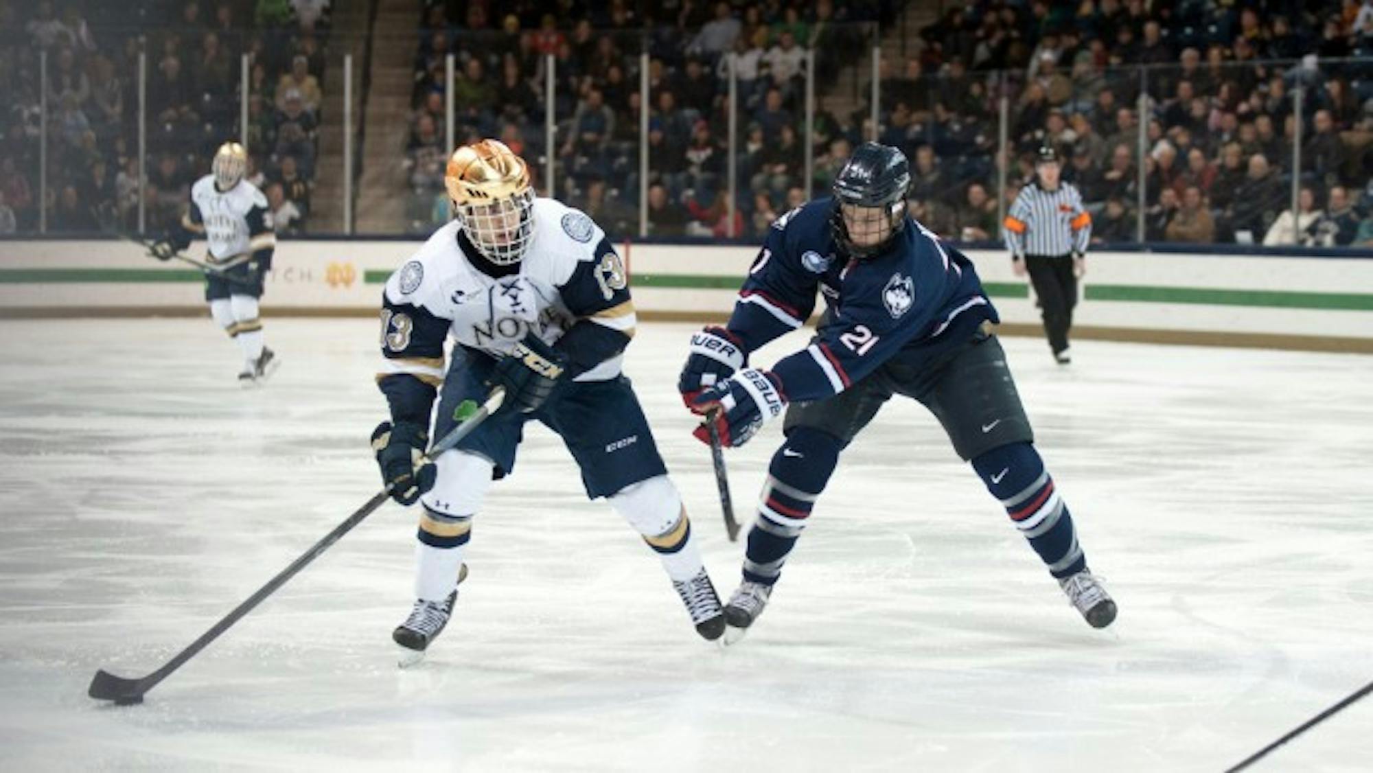 Irish sophomore center Vince Hinostroza shields the puck from a UConn defender during Notre Dame's  3-3 tie Jan. 16.