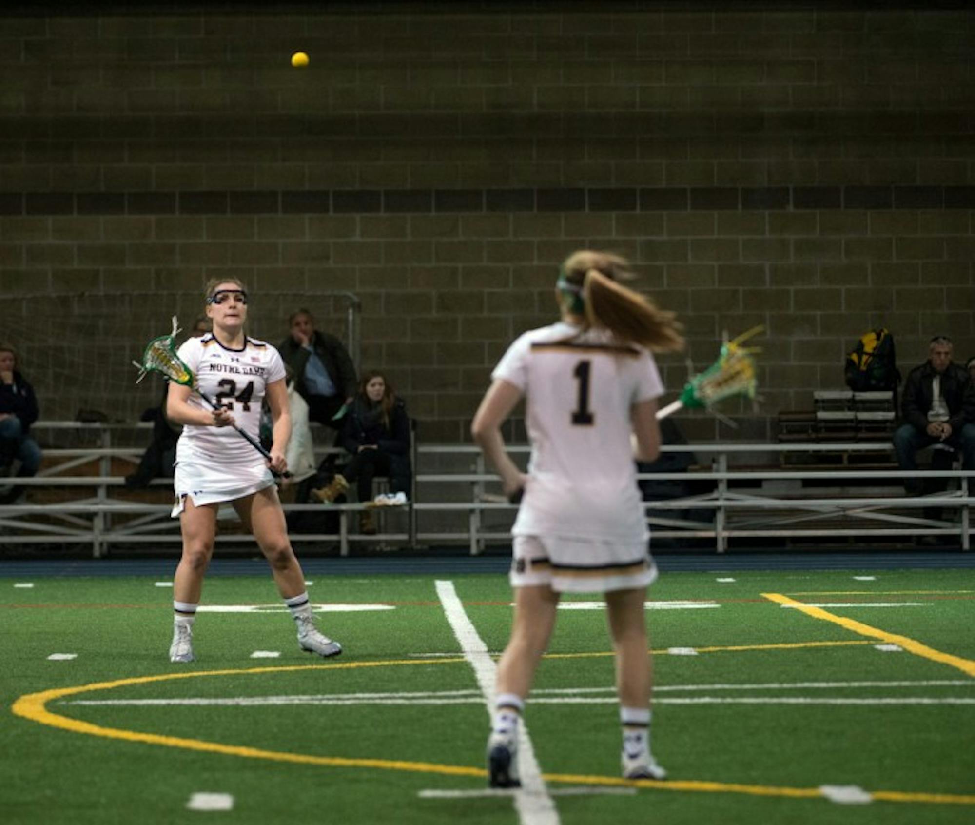 Irish sophomore Casey Pearsall, left, catches a pass from junior Kiera McMullan during a 17-5 win over Detroit Feb. 15.