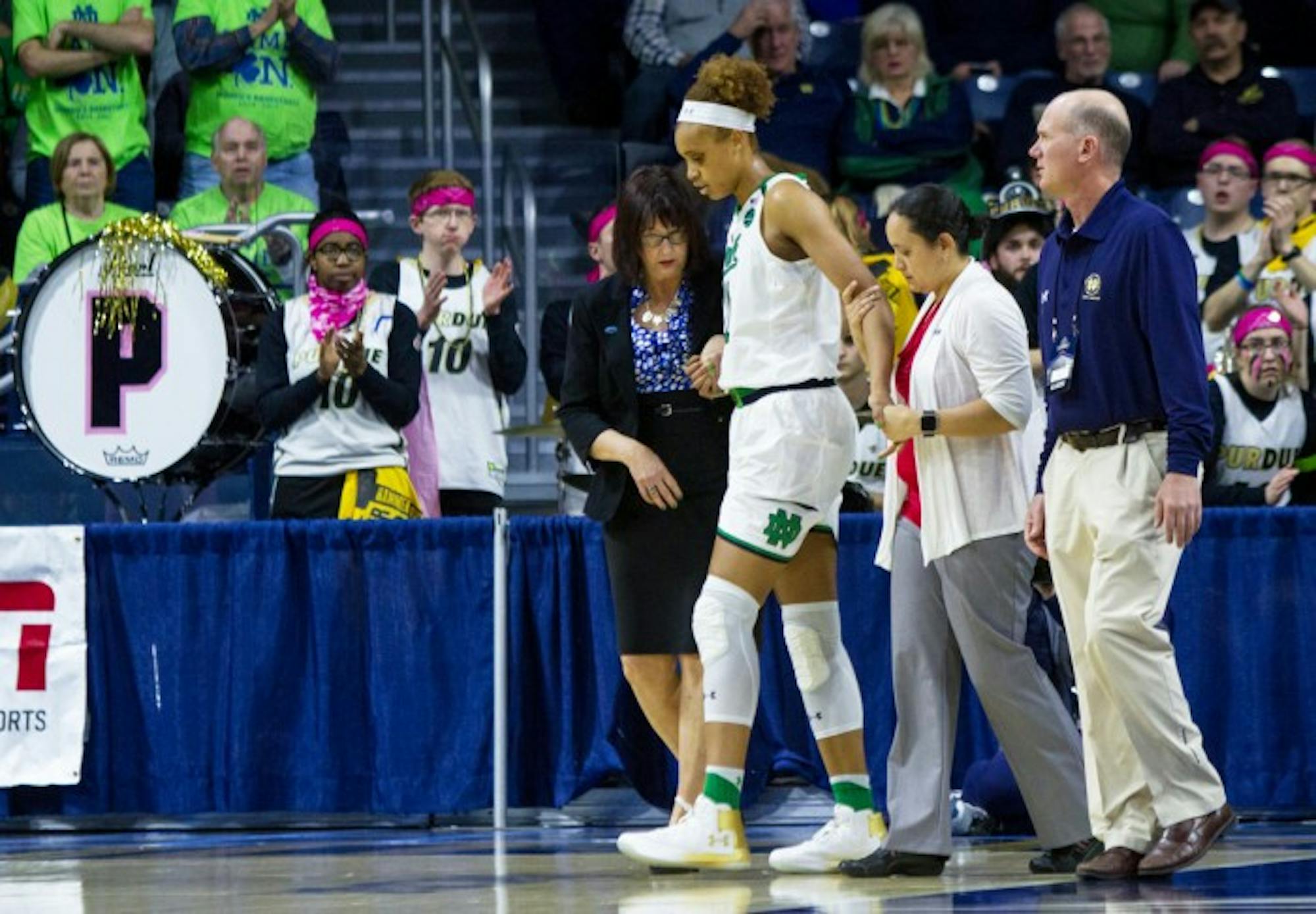 Irish junior forward Brianna Turner walks off the court and heads toward the locker room with assistance from team trainers during Notre Dame’s 88-82 win over Purdue on Sunday at Purcell Pavilion.