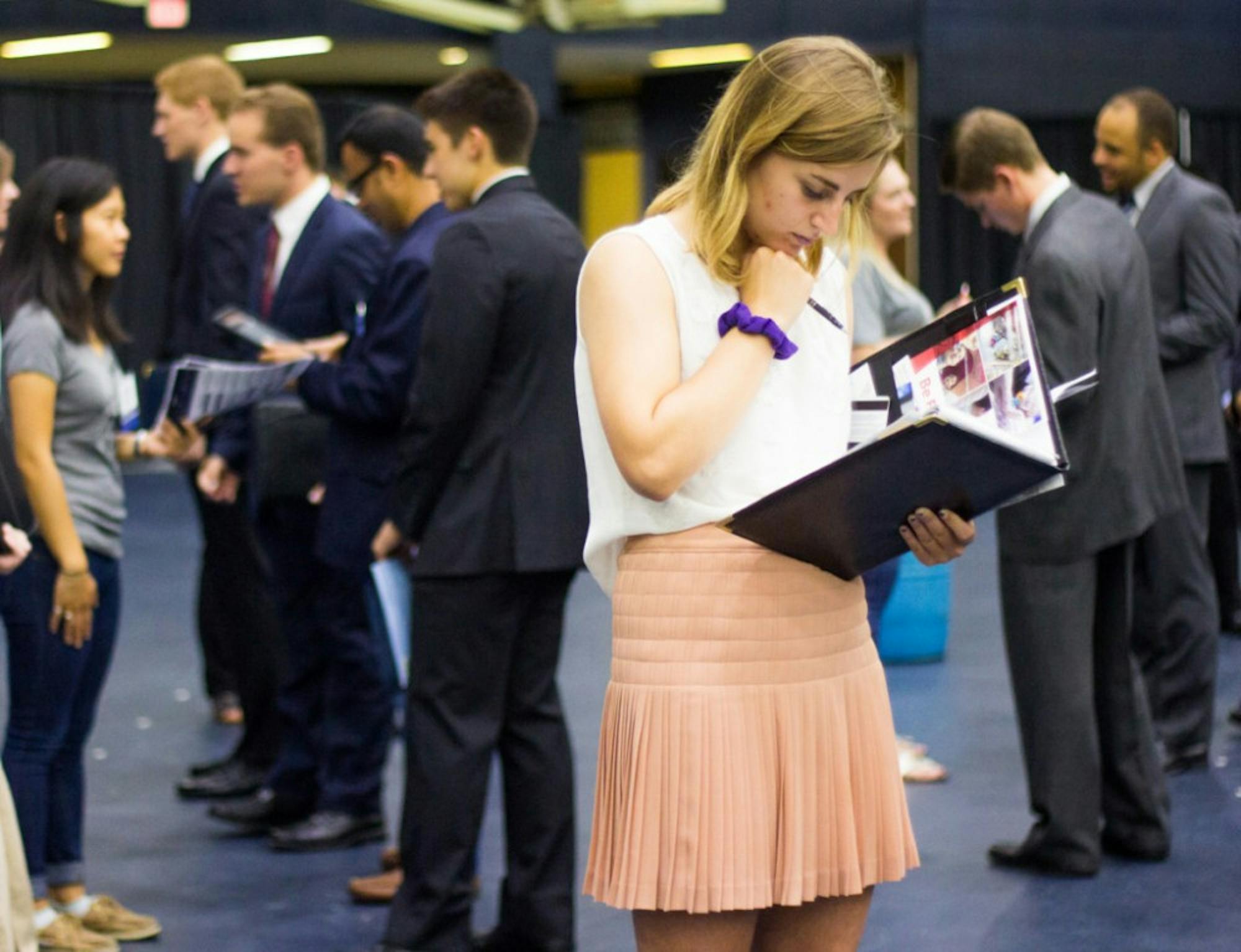 A student reviews informational brochures provided by visiting companies at the Fall Career Expo. The Expo, held in the Joyce Fieldhouse, allowed students to meet and interact with prospective employers.