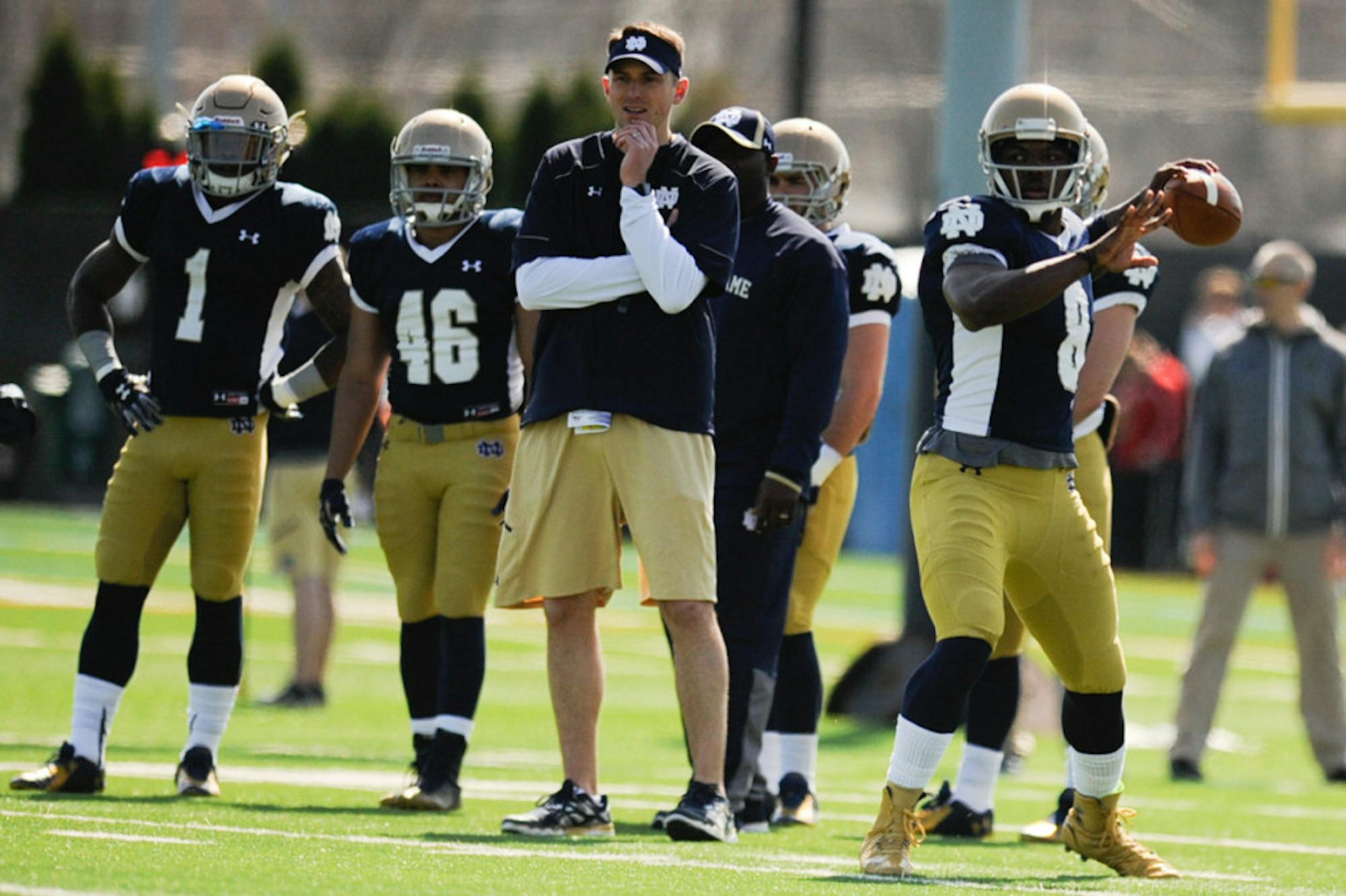 Irish offensive coordinator and quarterbacks coach Mike Sanford watches as junior quarterback Malik Zaire winds up for a pass during Notre Dame’s practice last Saturday at LaBar Practice Complex.