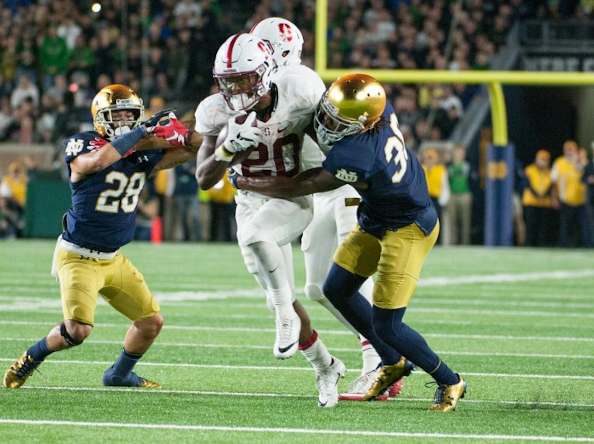 Irish senior cornerback Cole Luke wraps up Stanford sophomore running back Bryce Love during Notre Dame’s loss to Stanford on Oct. 15. Luke had two interceptions when the Irish played Stanford in 2014.