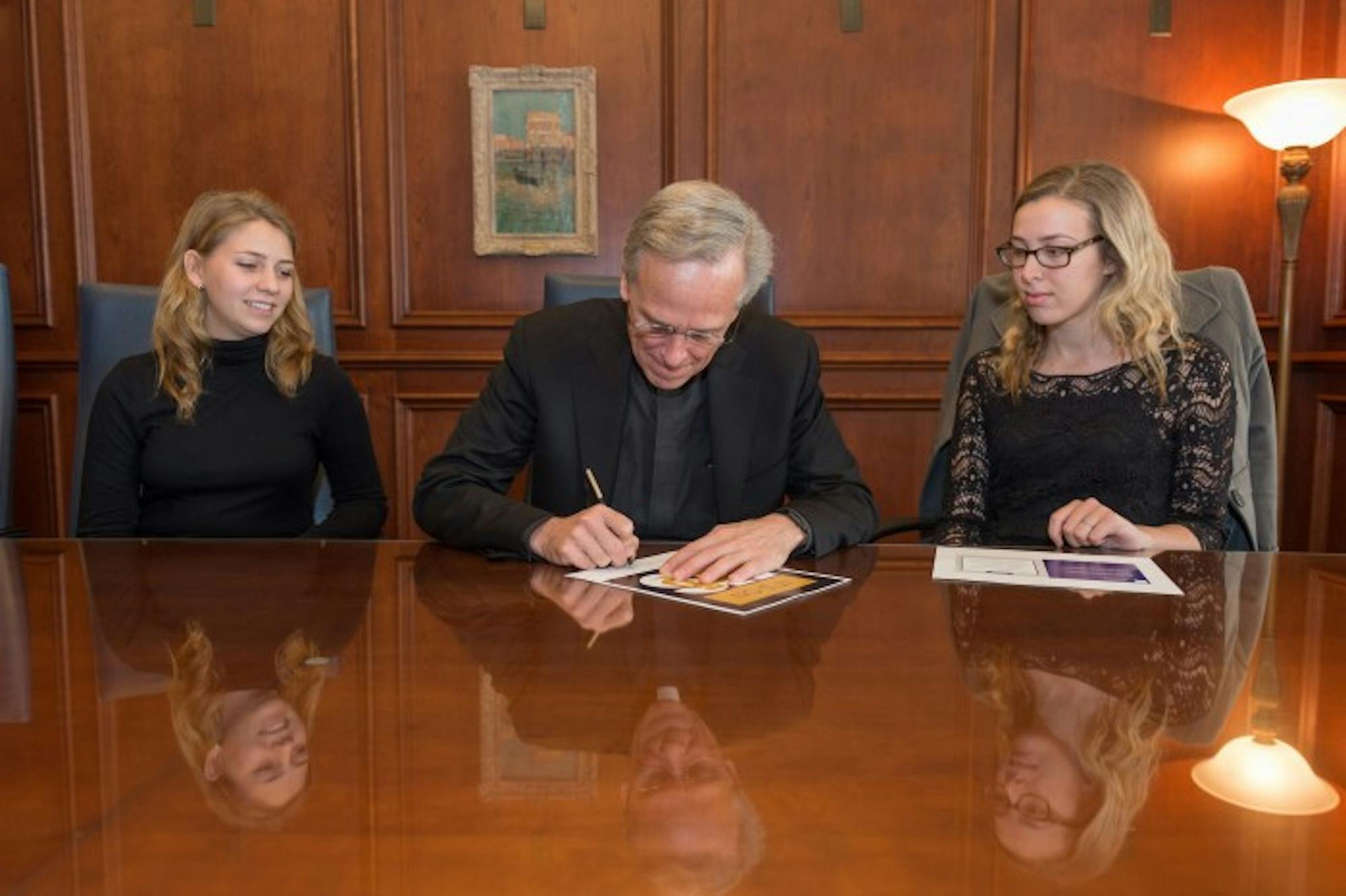 University President Fr. John Jenkins signs the