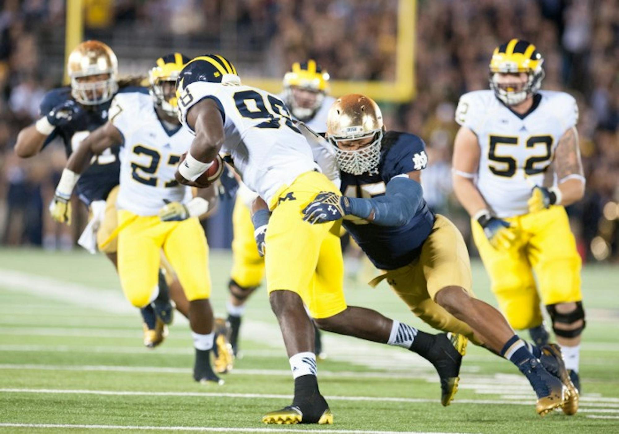 Irish junior defensive end Romeo Okwara tries to bring down Michigan graduate student quarterback Devin Gardner during Notre Dame’s 31-0 win over the Wolverines on Saturday at Notre Dame Stadium.