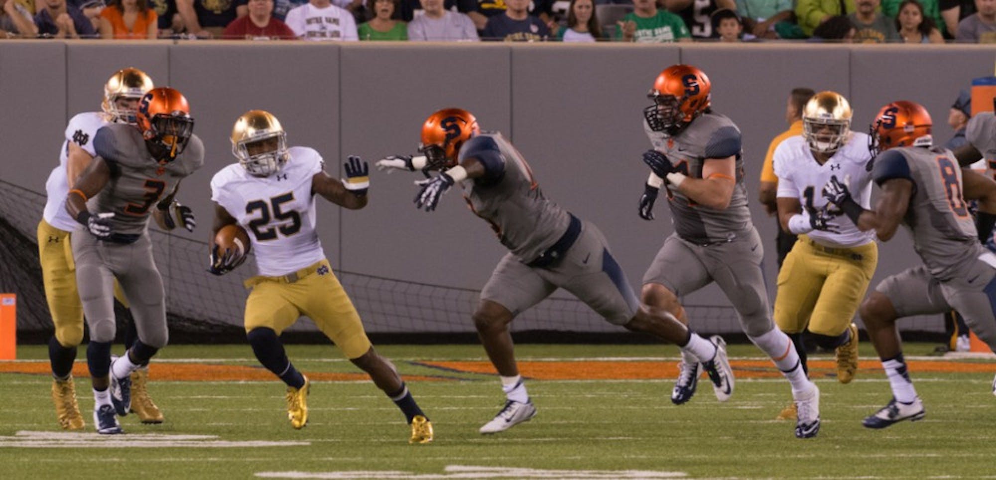 Irish sophomore running back Tarean Folston attempts to break away from a trio of Syracuse defenders during Notre Dame’s 31-15 win Saturday night over the Orange.