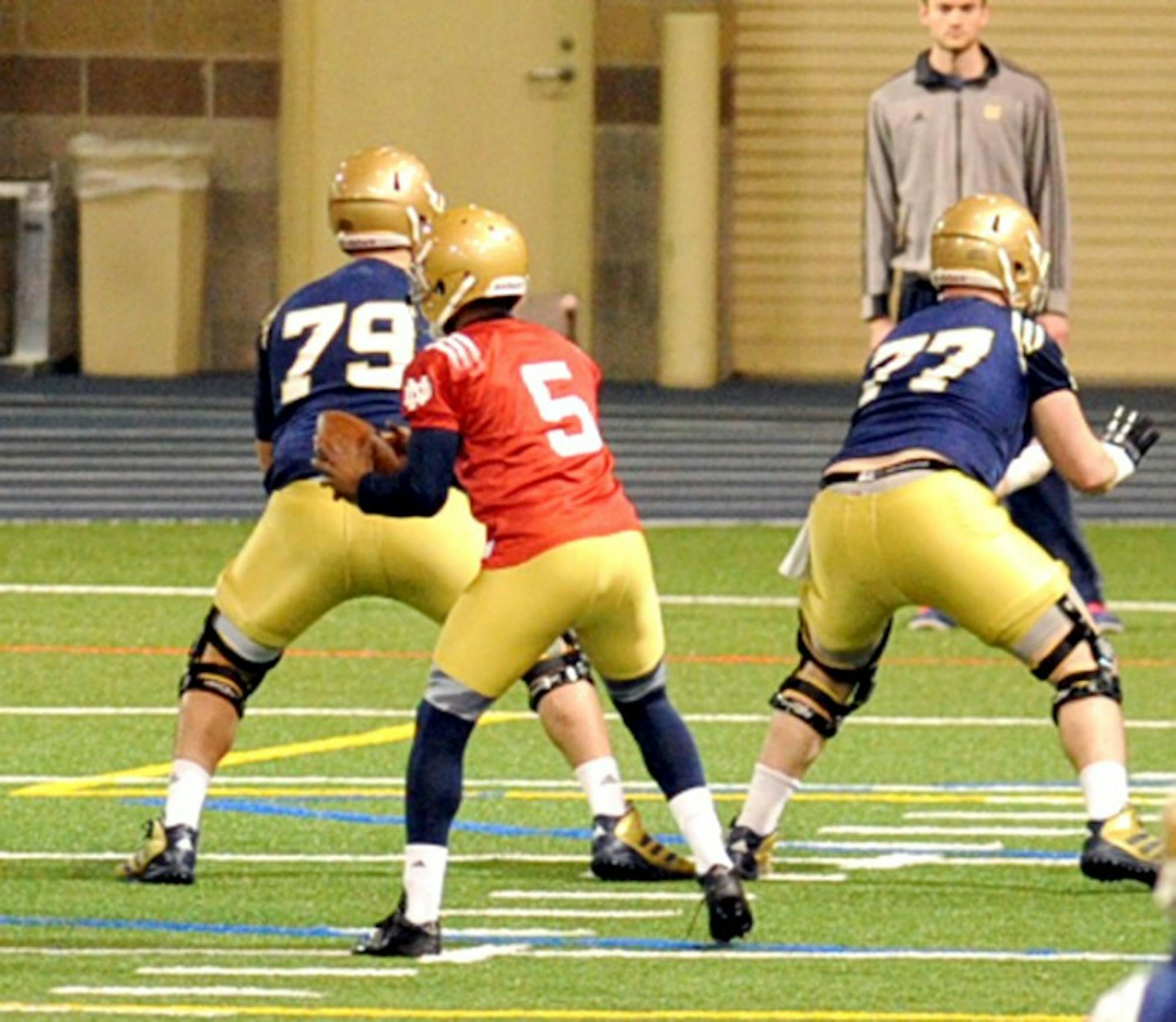 Senior quarterback Everett Golson (5) looks to hand the ball off at Notre Dame's first spring practice Monday at Loftus Sports Center.