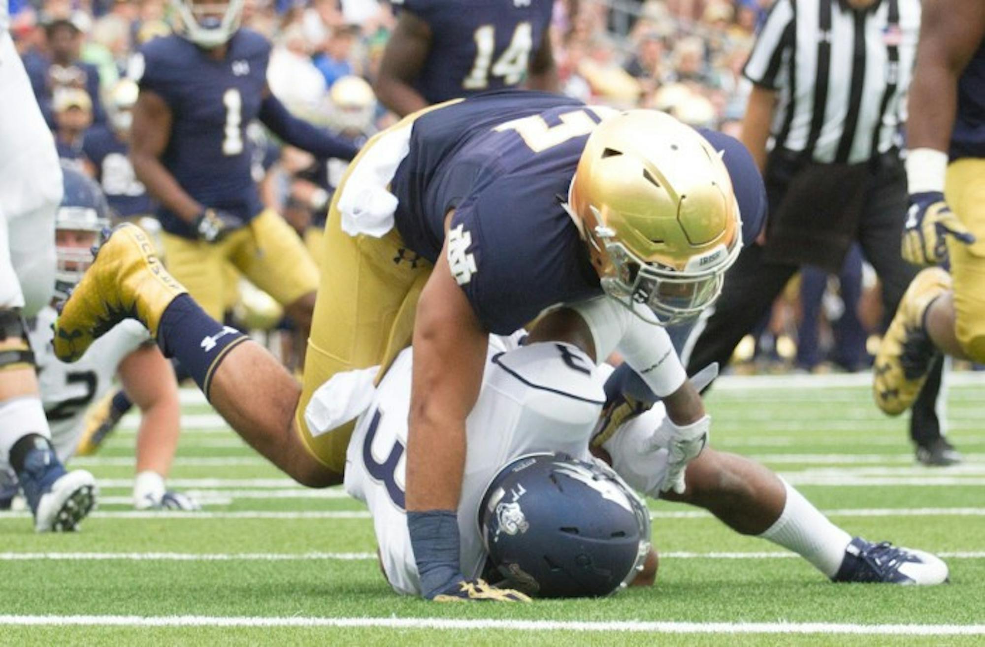 Senior linebacker and team captain James Onwualu finishes tackling Nevada sophomore receiver Ahki Mohammad in the backfield during Notre Dame’s victory over the Wolf Pack last weekend. Onwualu finished the game with five tackles, tied for most on the team.