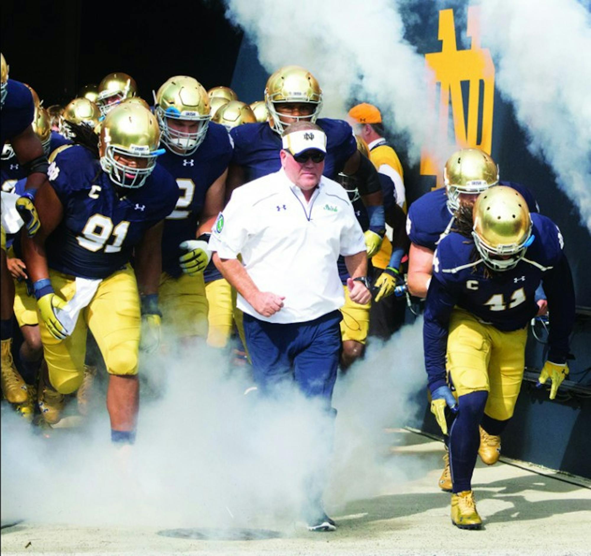 Irish head coach Brian Kelly leads his team onto the field before Notre Dame’s 62-27 win against Massachusetts on Sept. 26. Kelly is a perfect 5-0 so far in Shamrock Series games.