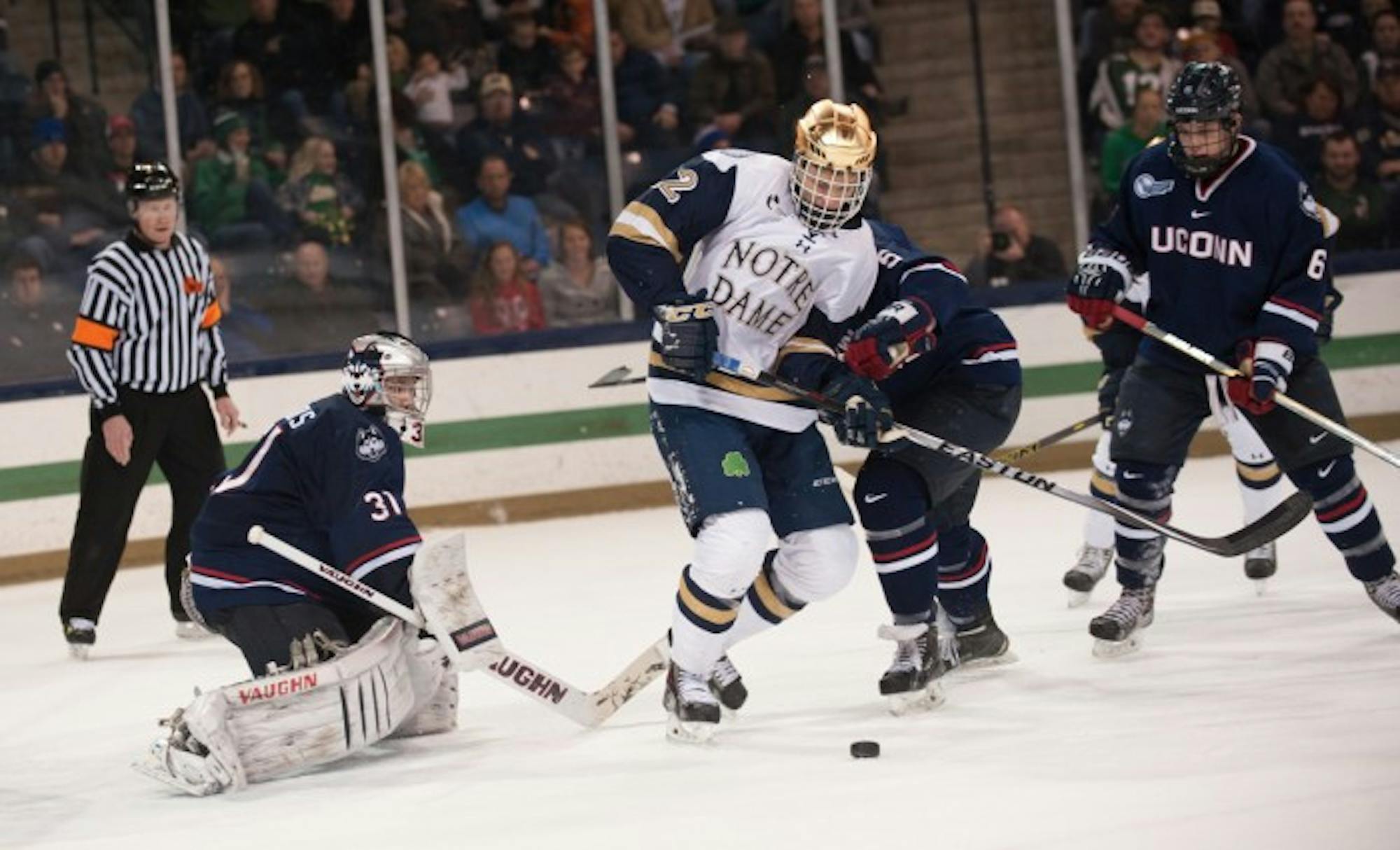 Senior left wing Mario Lucia fights for the puck during a 3-3 tie against Connecticut on Jan. 16 at Compton Family Ice Arena.