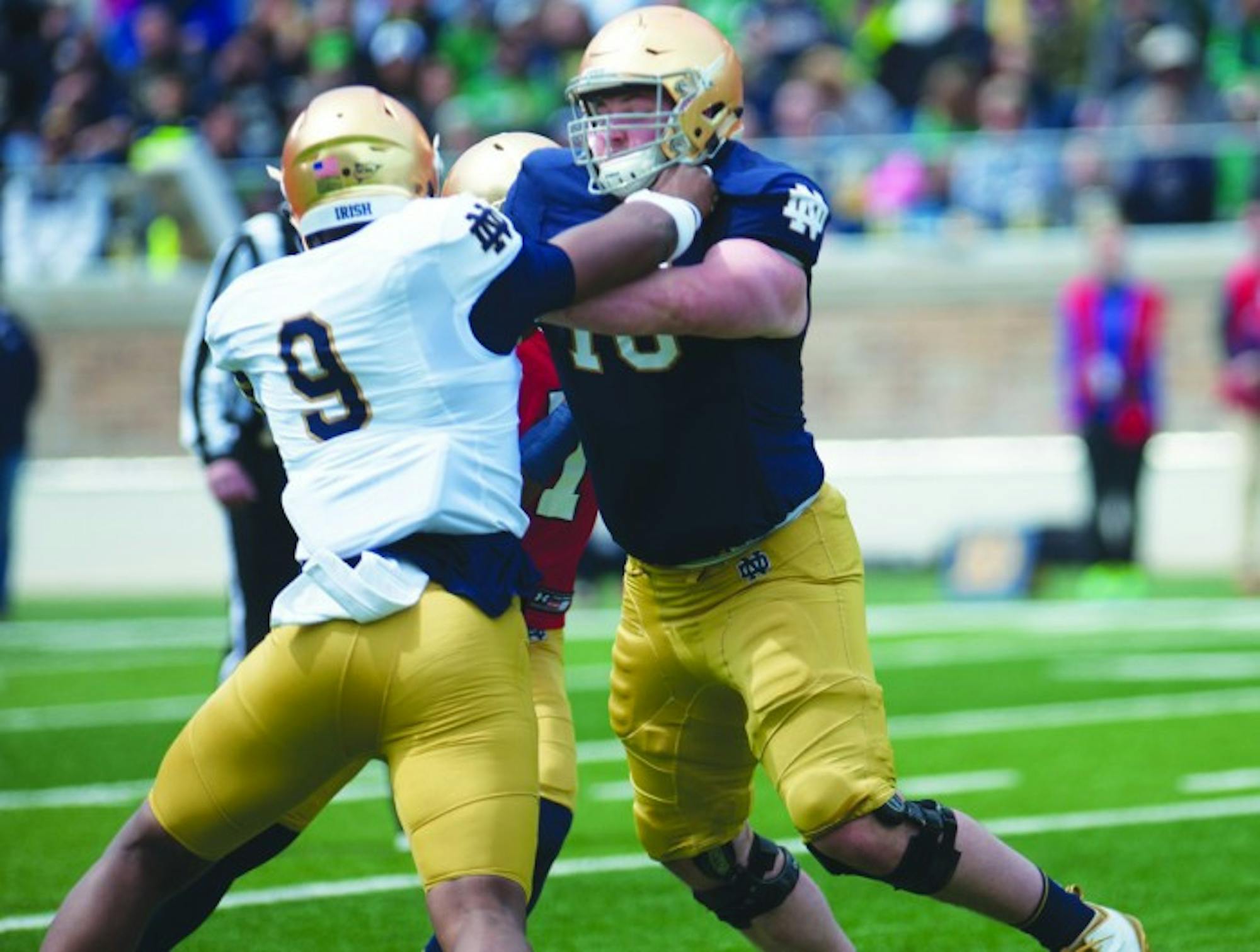 Irish sophomore defensive lineman Daelin Hayes, left, rushes the passer during the Blue-Gold game at Notre Dame Stadium on Saturday. Hayes had seven tackles and three sacks in the game.