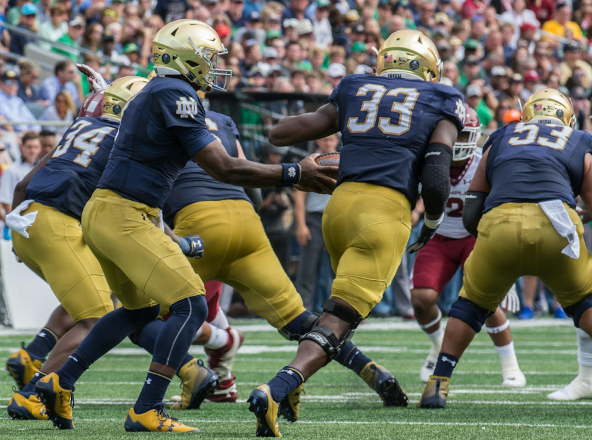 Irish junior running back Josh Adams accepts the handoff from junior quarterback Brandon Wimbush during Notre Dame's 49-16 win over Temple on Saturday at Notre Dame Stadium.