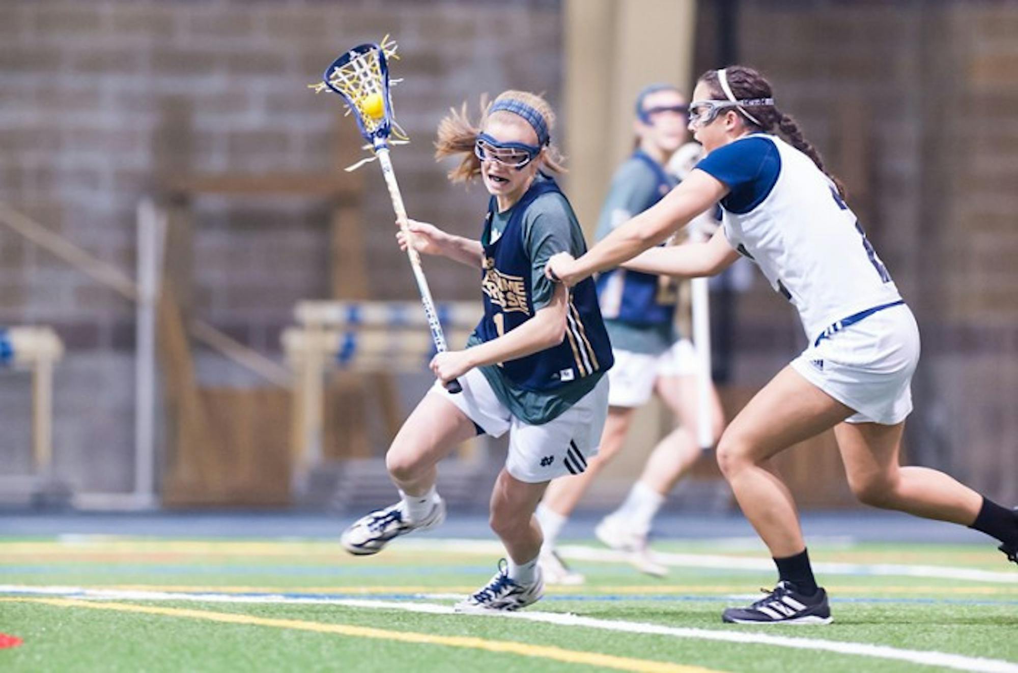 Sophomore attack Kiera McMullan tries to power past a Michigan defender during Notre Dame’s 19-7 exhibition victory over the Wolverines on Feb. 8 at the Loftus Sports Center.