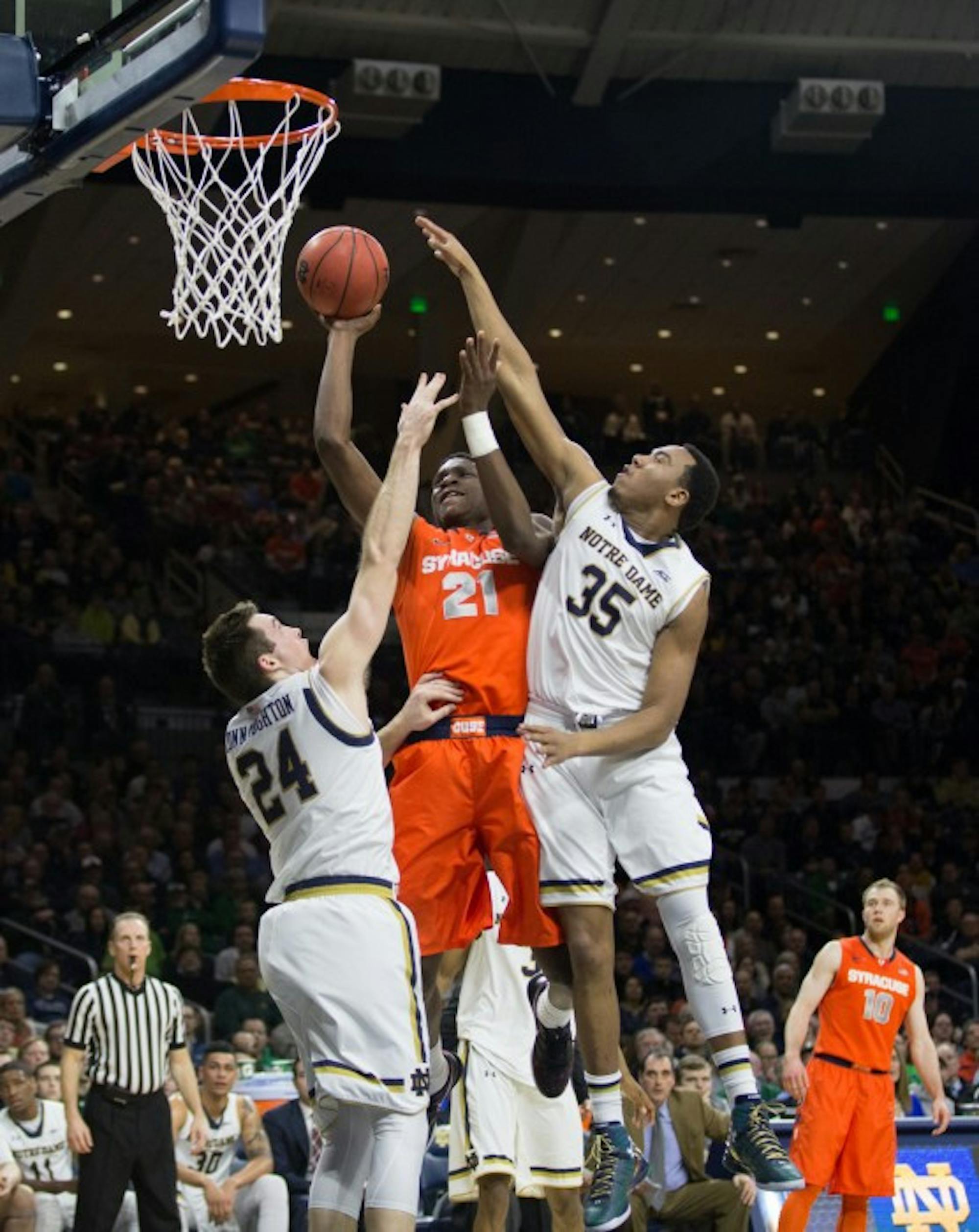Senior Pat Connaughton, left, and freshman Bonzie Colson try to block a Syracuse shot in Tuesday’s loss at Purcell Pavilion.
