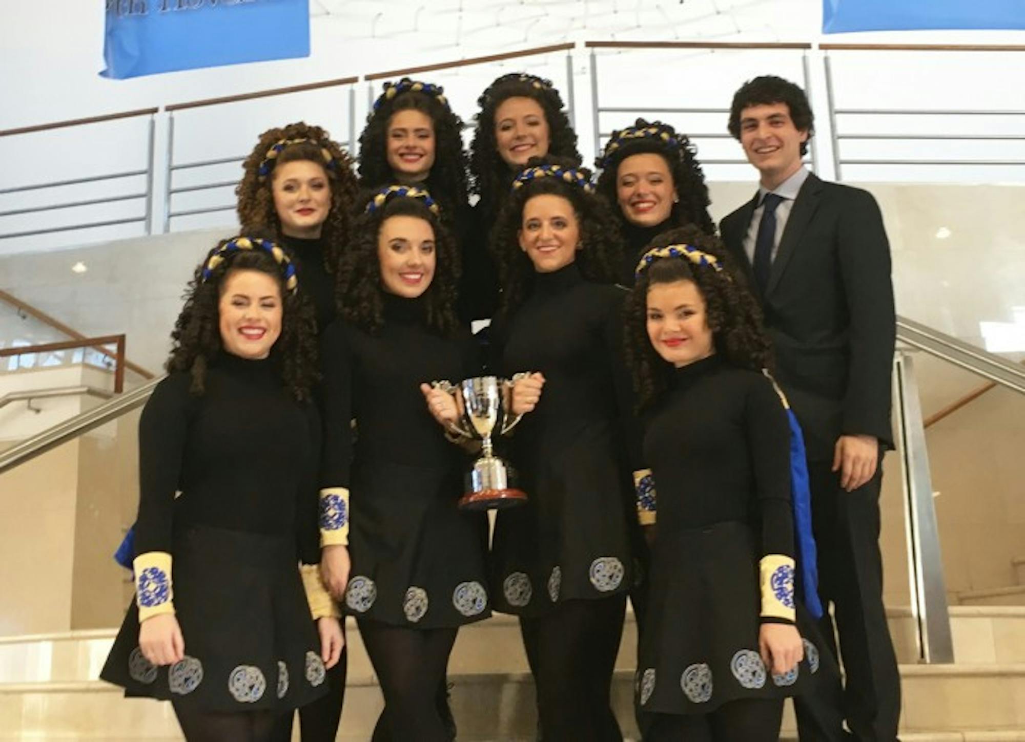 The eight ceili dancers on the Notre Dame/Saint Mary’s Irish Dance Team and their student coach, Robert Black, hold their championship trophy.