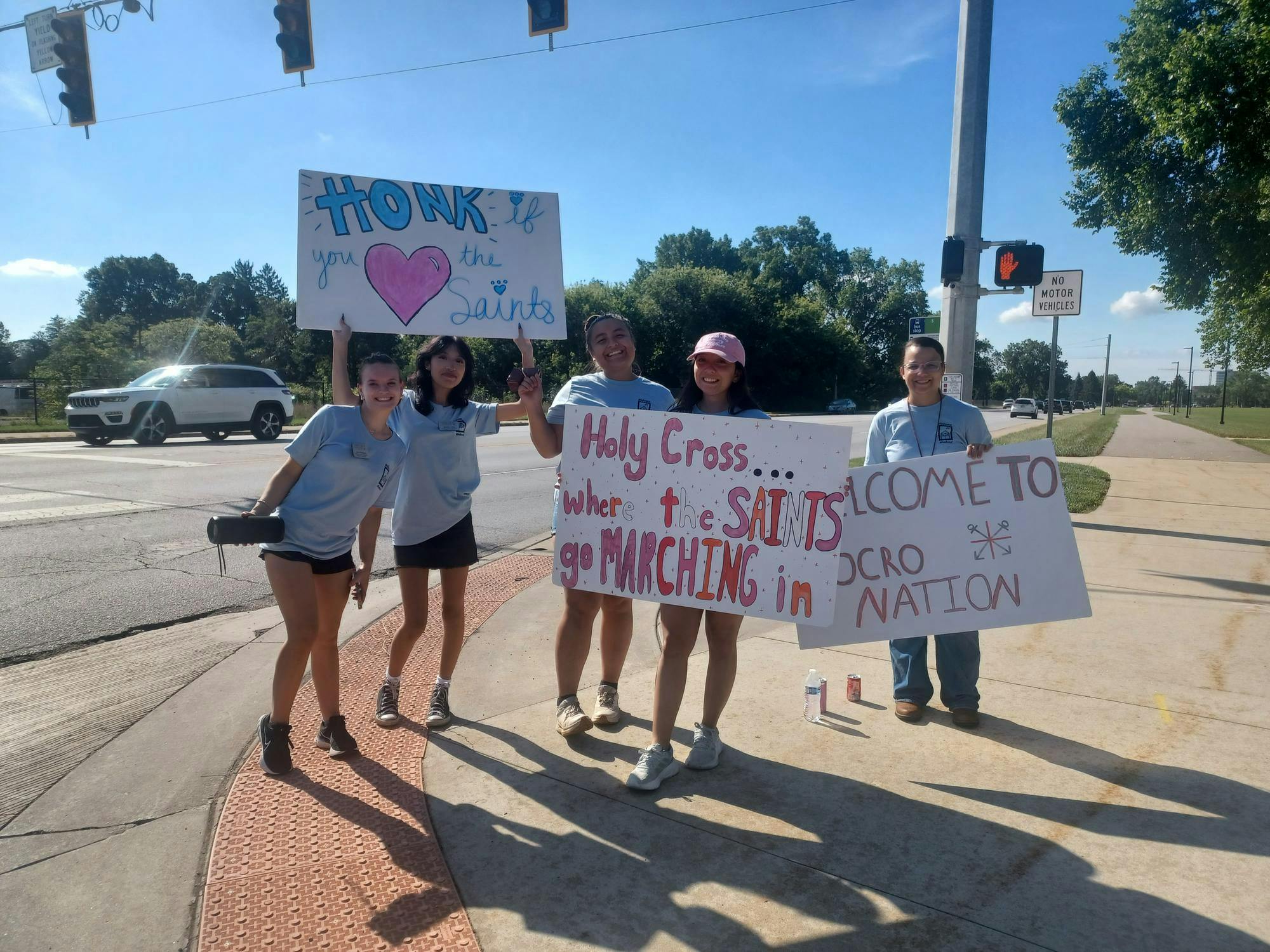 Returning students hold signs welcoming freshmen to Holy Cross