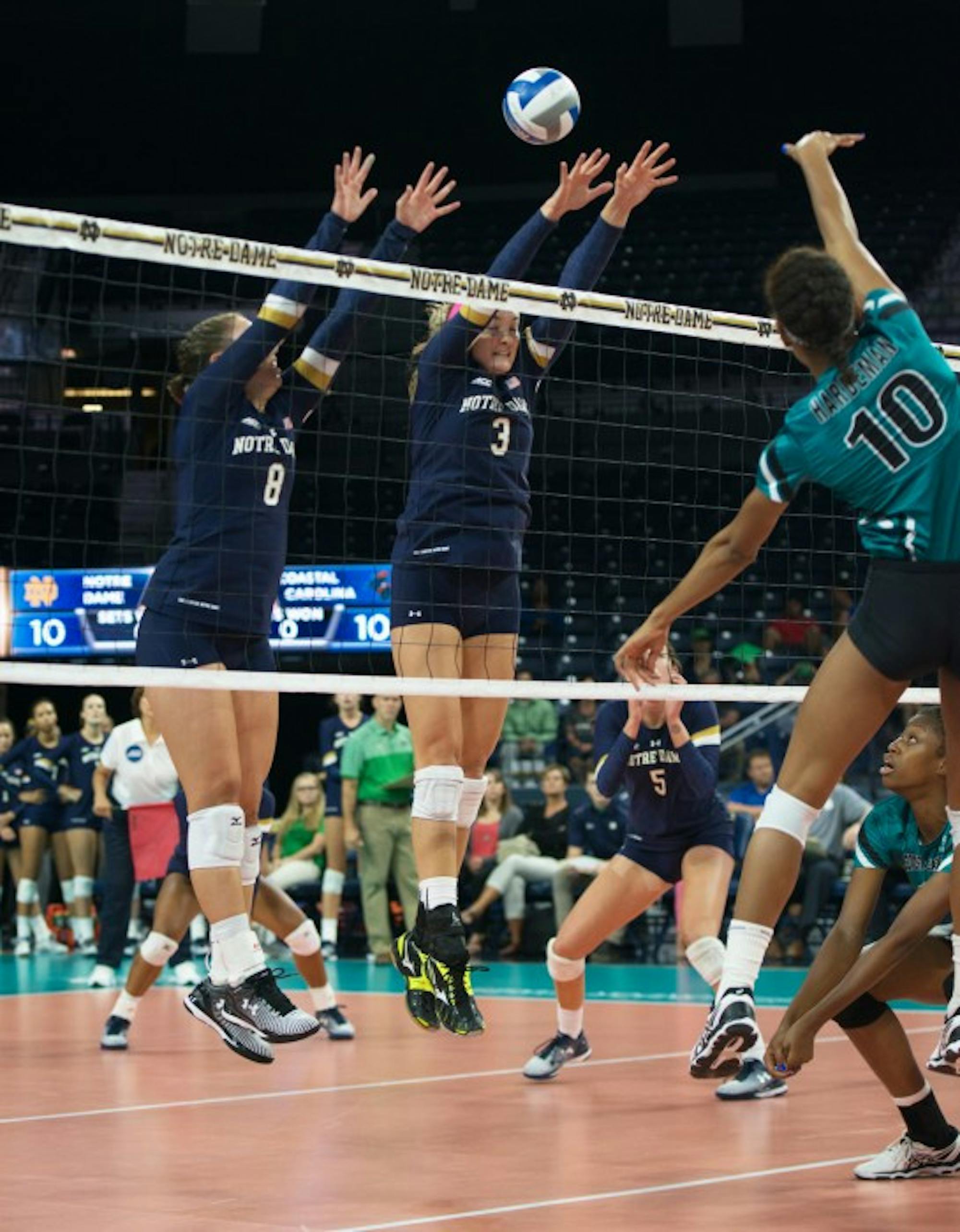Irish junior setter Caroline Holt, left, and junior middle blocker Sam Fry attempt a block during Notre Dame’s 3-0 loss to Coastal Carolina on Sept. 3. Fry leads the team with 29 blocks on the season.