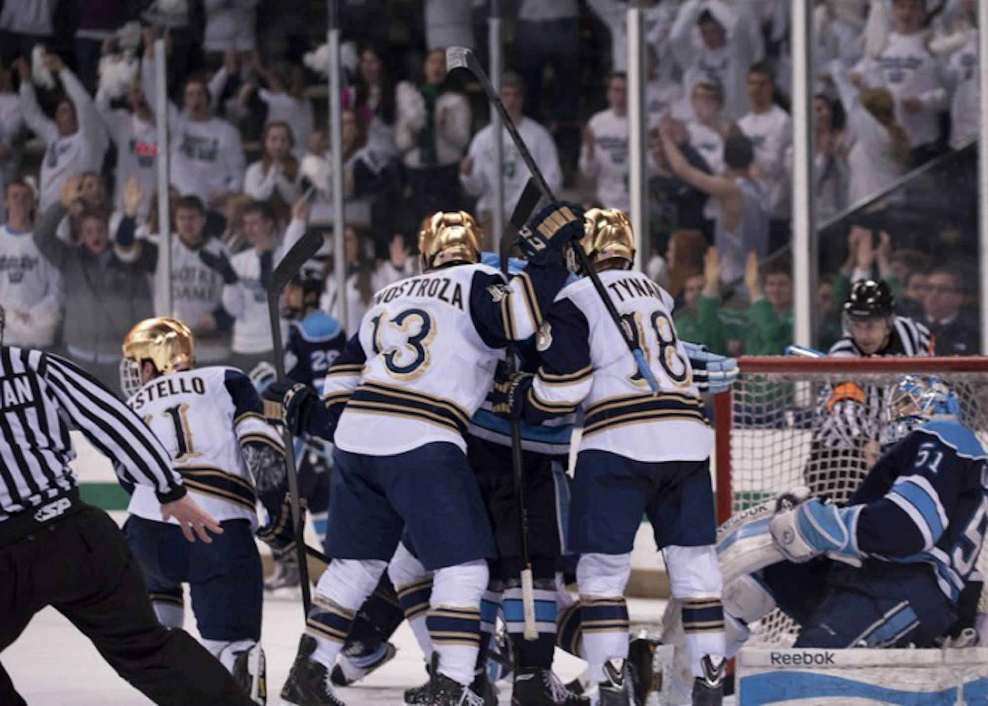 Freshman center Vince Hinostroza, center, and senior center T.J. Tynan jostle with Maine players during Maine’s 2-1 win over the Irish on Feb. 7.  A tying goal scored by senior left wing Jeff Costello was called off by the officials.