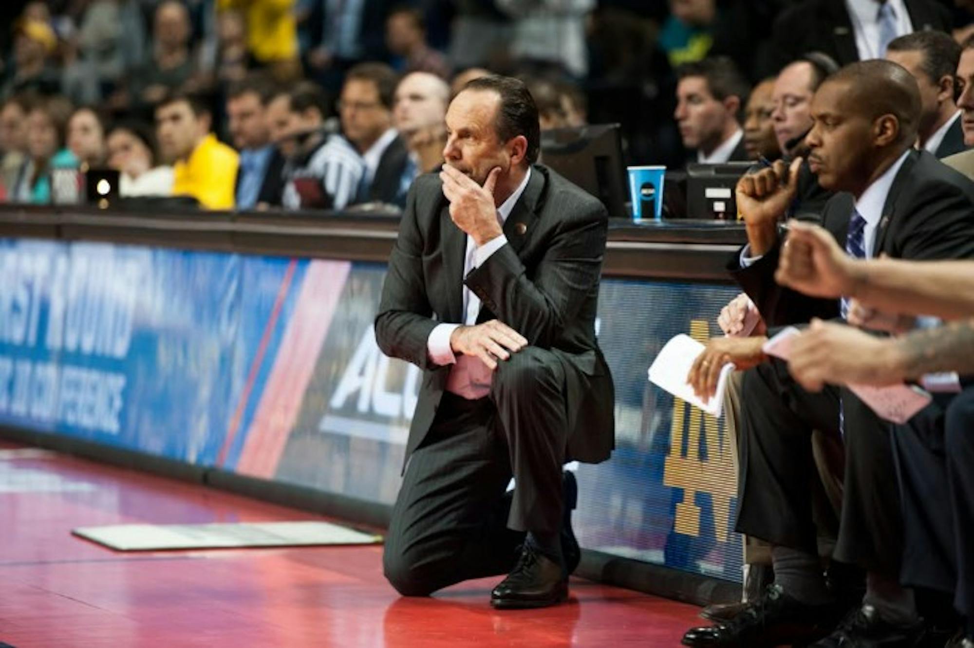 Irish head coach Mike Brey kneels on the sideline during Notre Dame’s 70-63 win over Michigan on Friday in Brooklyn, New York.