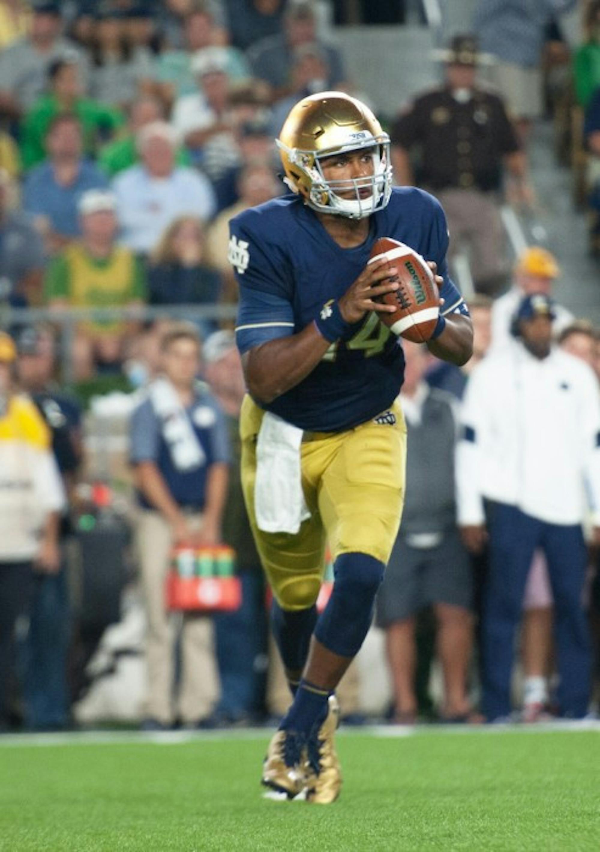 Irish junior quarterback DeShone Kizer rolls out for a pass during Notre Dame’s 36-28 loss against Michigan State on Saturday.
