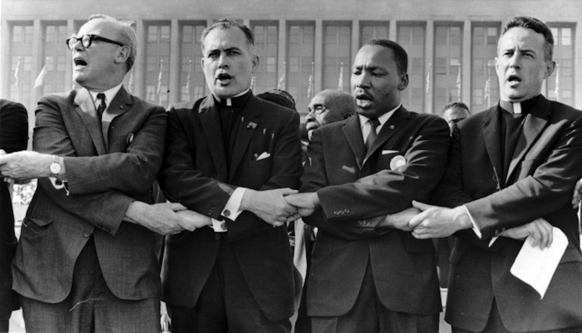 Fr. Hesburgh, second from left, links arms with Dr. Martin Luther King, Jr., to his right, and sings