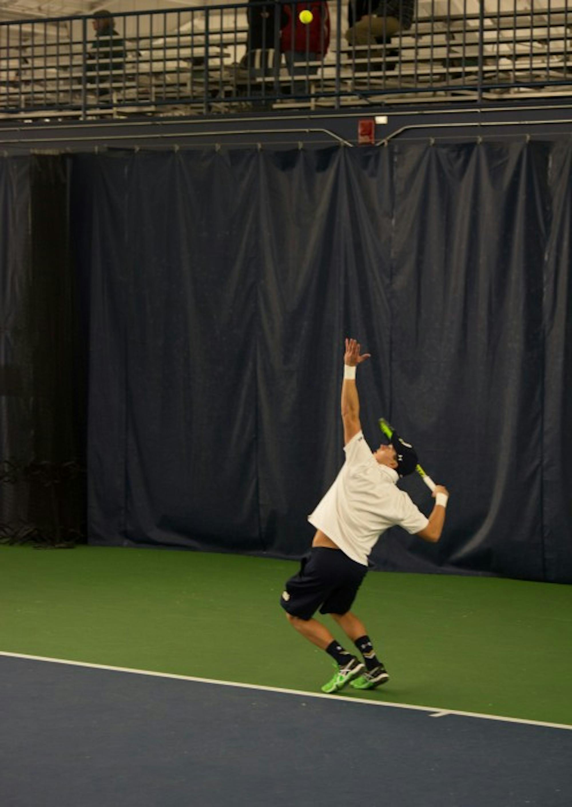 Irish junior Brendon Kempin tosses the ball for a serve during Notre Dame’s 5-2 win over Indiana on Feb. 7 at Eck Tennis Pavilion. Kempin’s doubles match went unfinished as the Irish won before it came to an end.