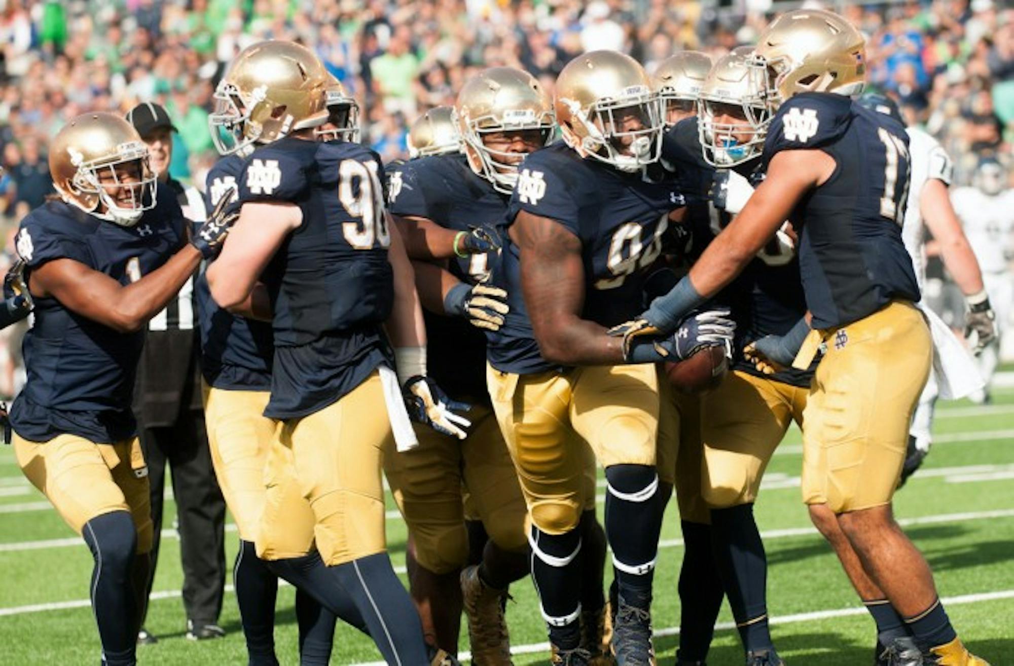 A gaggle of Notre Dame players celebrate an interception by senior defensive lineman Jarron Jones, center, in the second quarter of last weekend’s 39-10 victory over Nevada at Notre Dame Stadium.