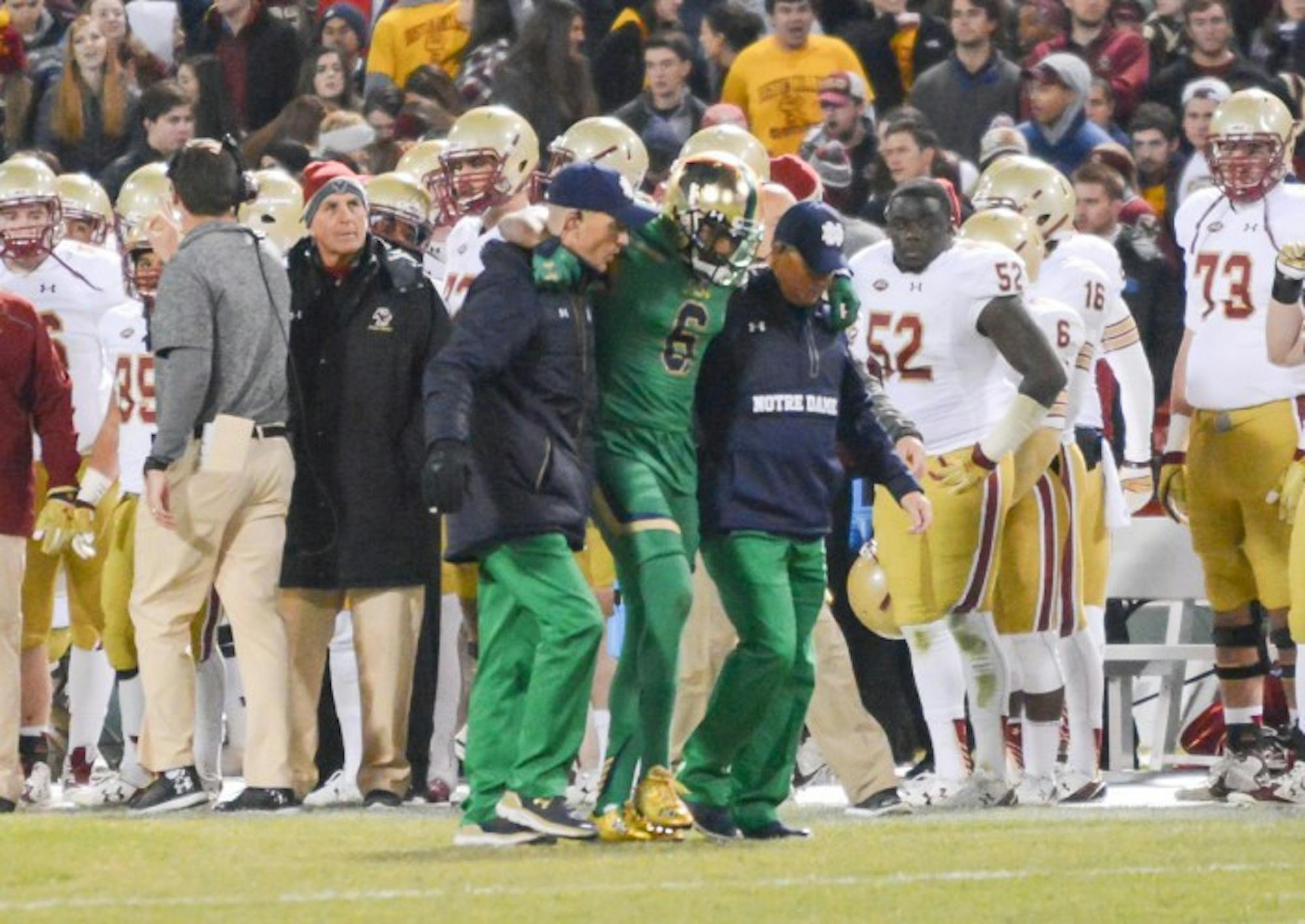 Senior cornerback KeiVarae Russell is helped off the field during Notre Dame’s 19-16 victory over Boston College on Saturday. Russell was diagnosed with a broken tibia and is out for six to eight weeks.