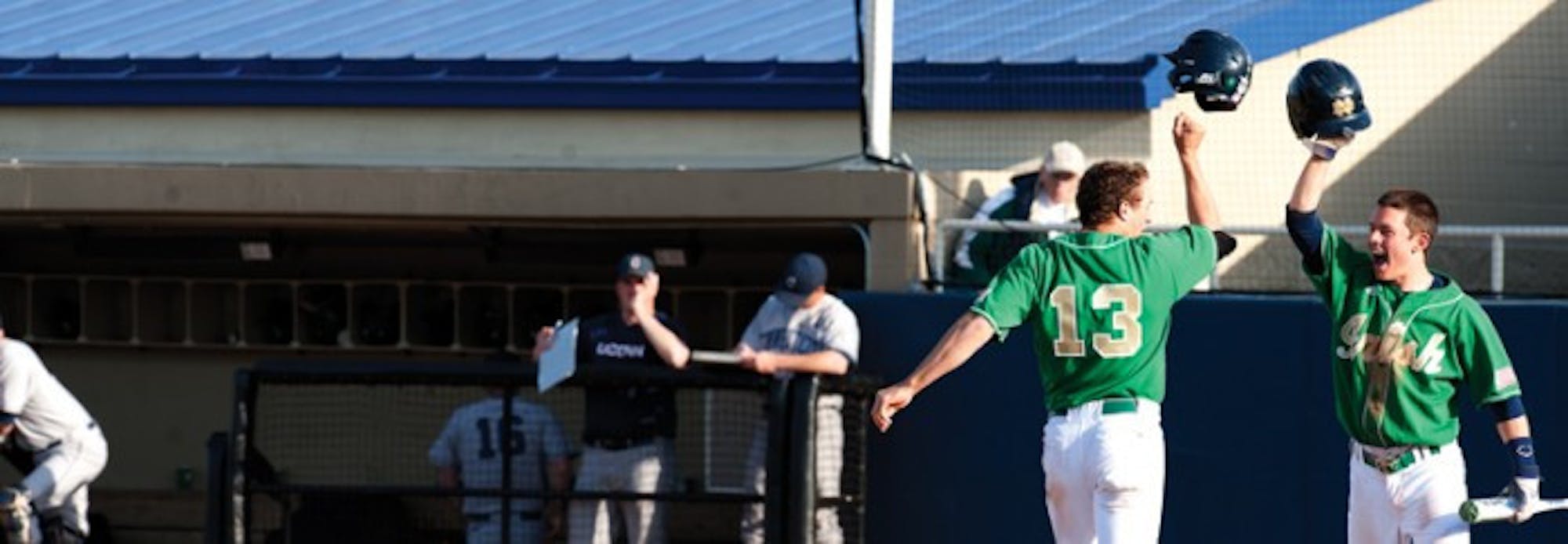 Irish junior Mac Hudgins (13) celebrates with a teammate during Notre Dame’s 12-2 victory over Connecticut on April 26 last season. Hudgins started 31 games for the Irish last season and had 29 doubles.