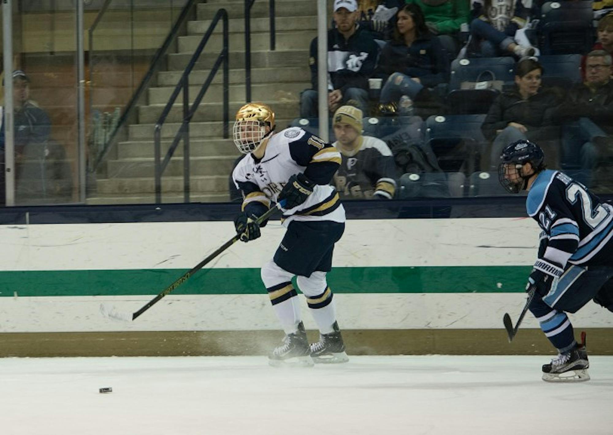 Sophomore center Jake Evans passes the puck during Notre Dame’s  5-1 win over Maine at Compton Family Ice Arena on Saturday.