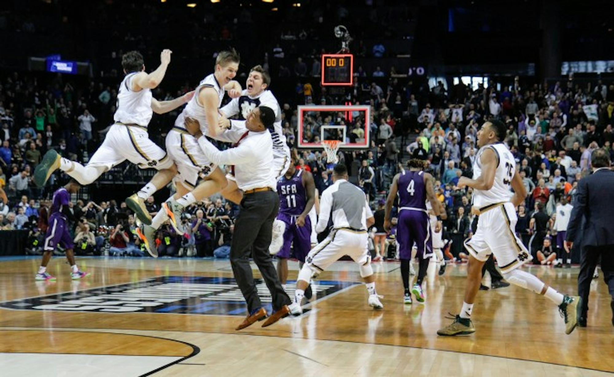 Irish players celebrate following the final buzzer in Notre Dame’s 76-75 win over Stephen F. Austin on Sunday at Barclays Center.
