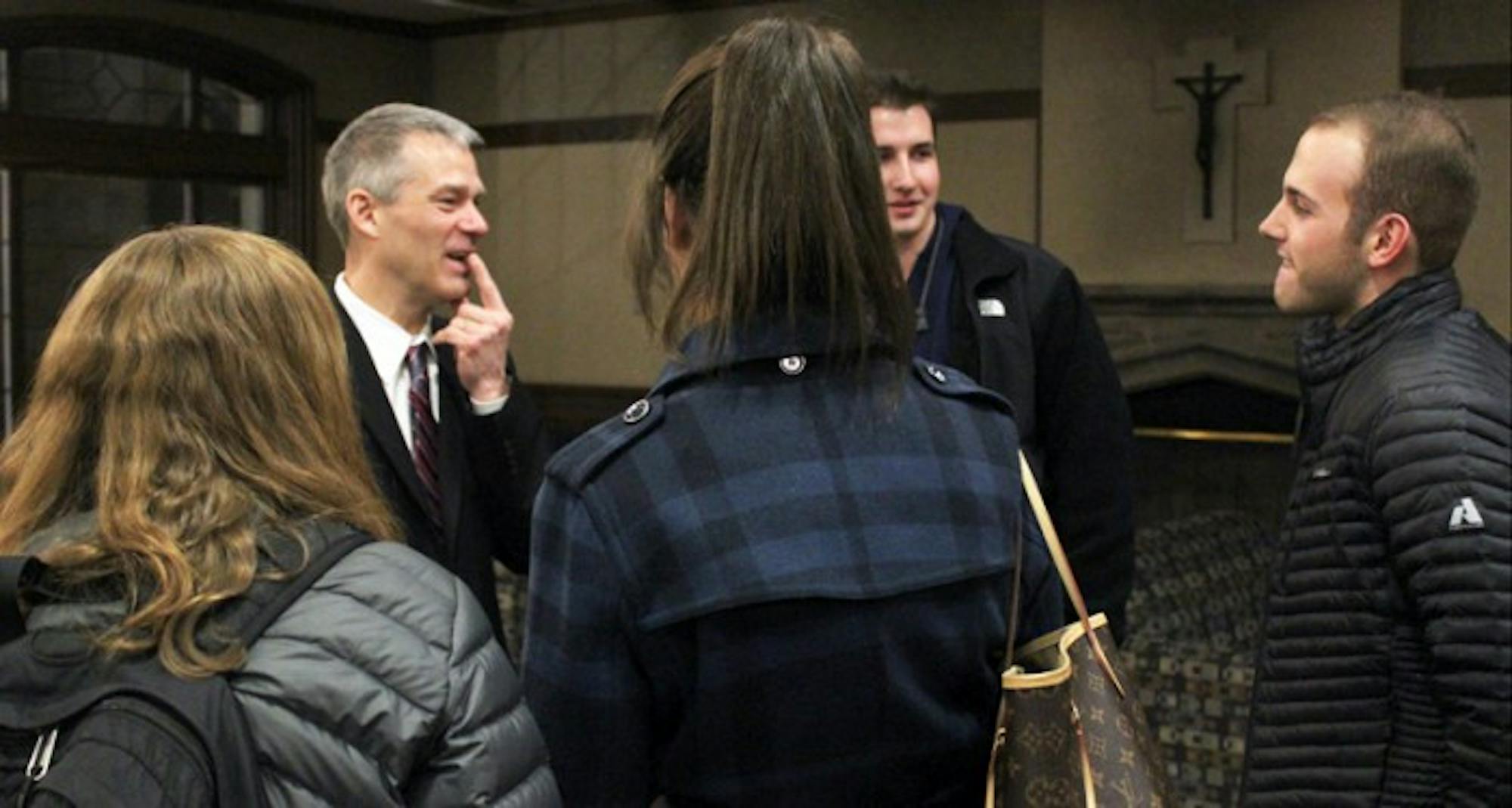 Professor of finance Carl Ackermann talks with students following his speech on Tuesday evening in the Last Lecture series.