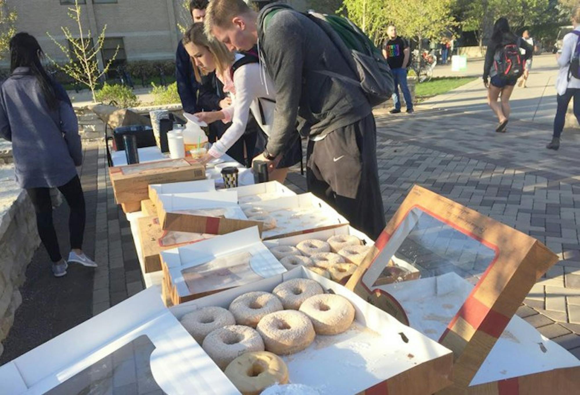 Students eat Rise'n Roll Bakery doughnuts outside of DeBartolo Hall on Monday as part of the week-long AnTostal celebration.