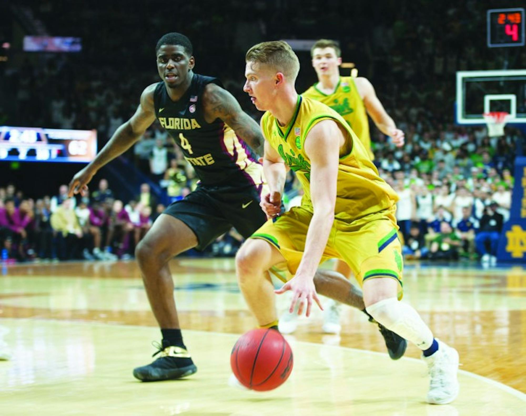 Irish sophomore guard Rex Pflueger dribbles past a Florida State defender during Notre Dame’s 84-72 victory Feb. 11 at Purcell Pavilion. Mike Brey said Pflueger would retain his starting spot this weekend.