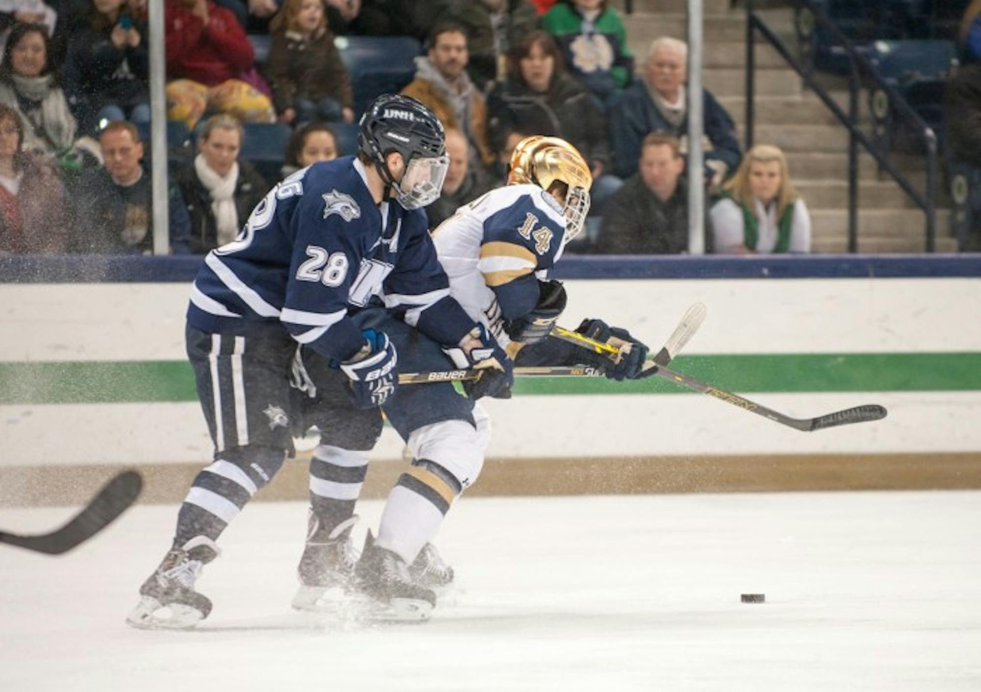 Senior center Thomas DiPauli battles with a New Hampshire defender during a 5-2 defeat at Compton Family Ice Arena on Jan. 30. DiPauli scored during the team’s 3-3 tie with Minnesota Duluth on Saturday.