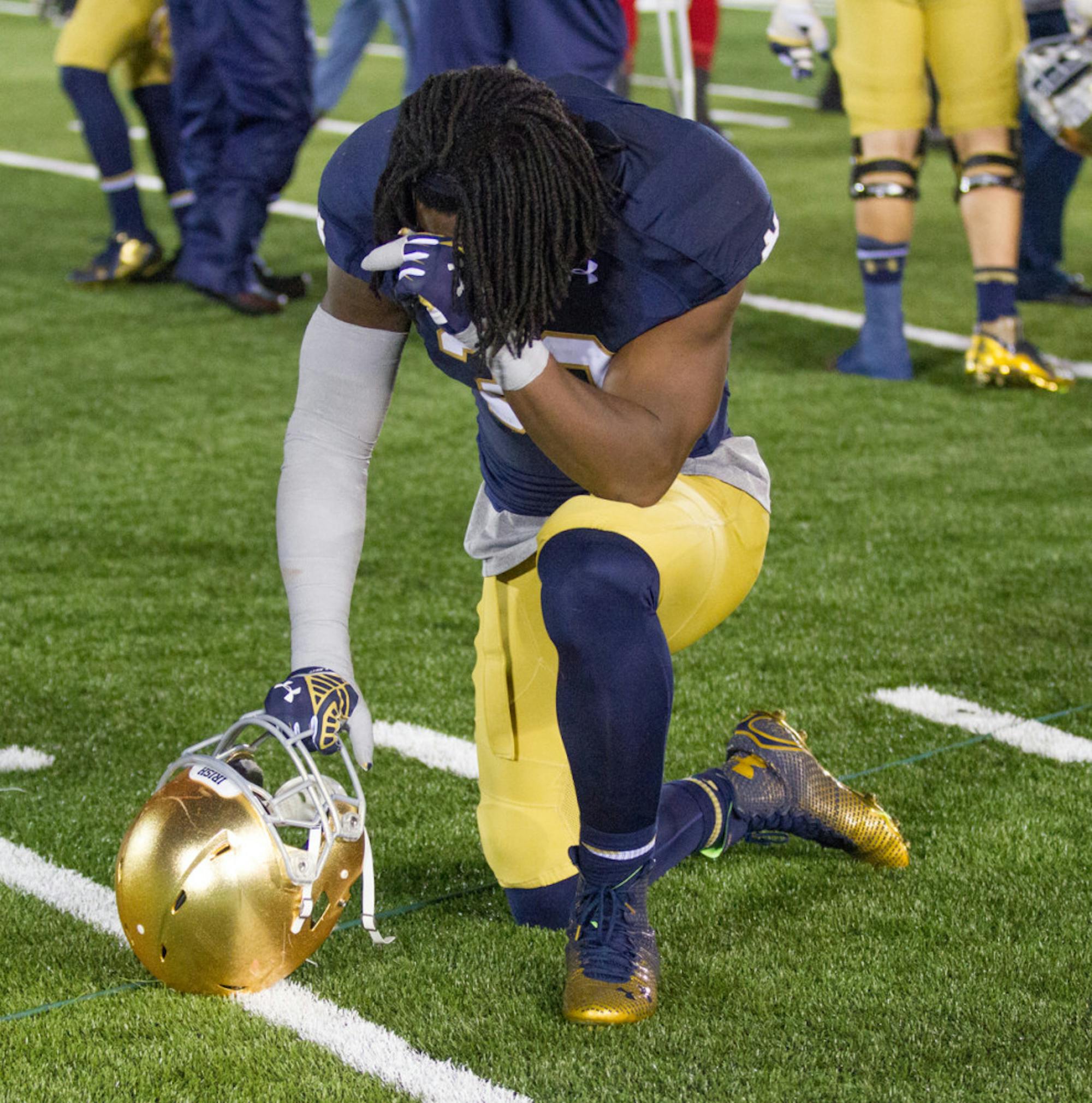 Irish sophomore linebacker Jaylon Smith drops to one knee after Notre Dame’s 31-28 loss to Louisville on Saturday at Notre Dame Stadium on Senior Day.
